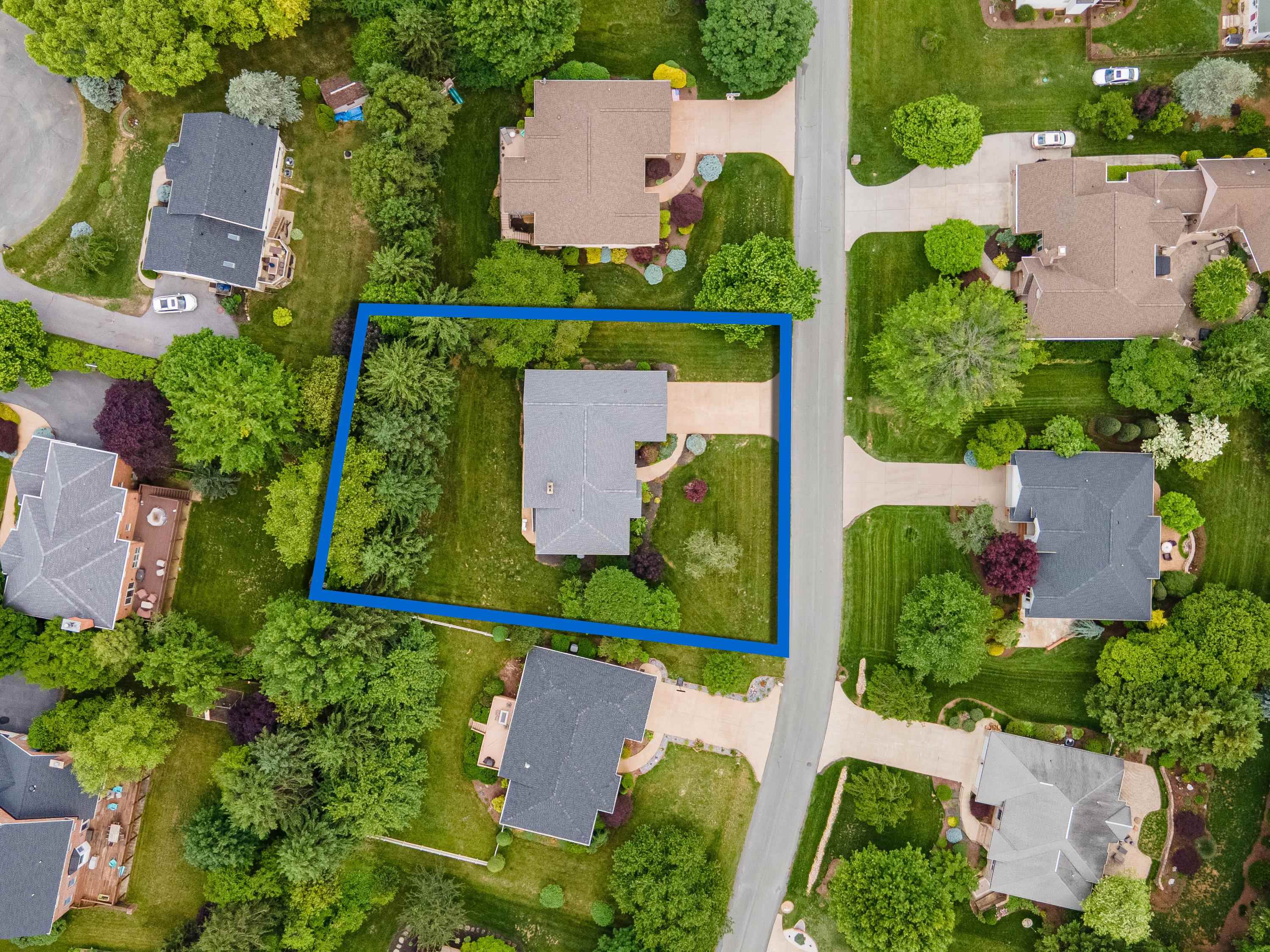 The aerial view highlights the spacious lot this home is located on, the mature landscaping surrounding the home, and the Barrington subdivision.