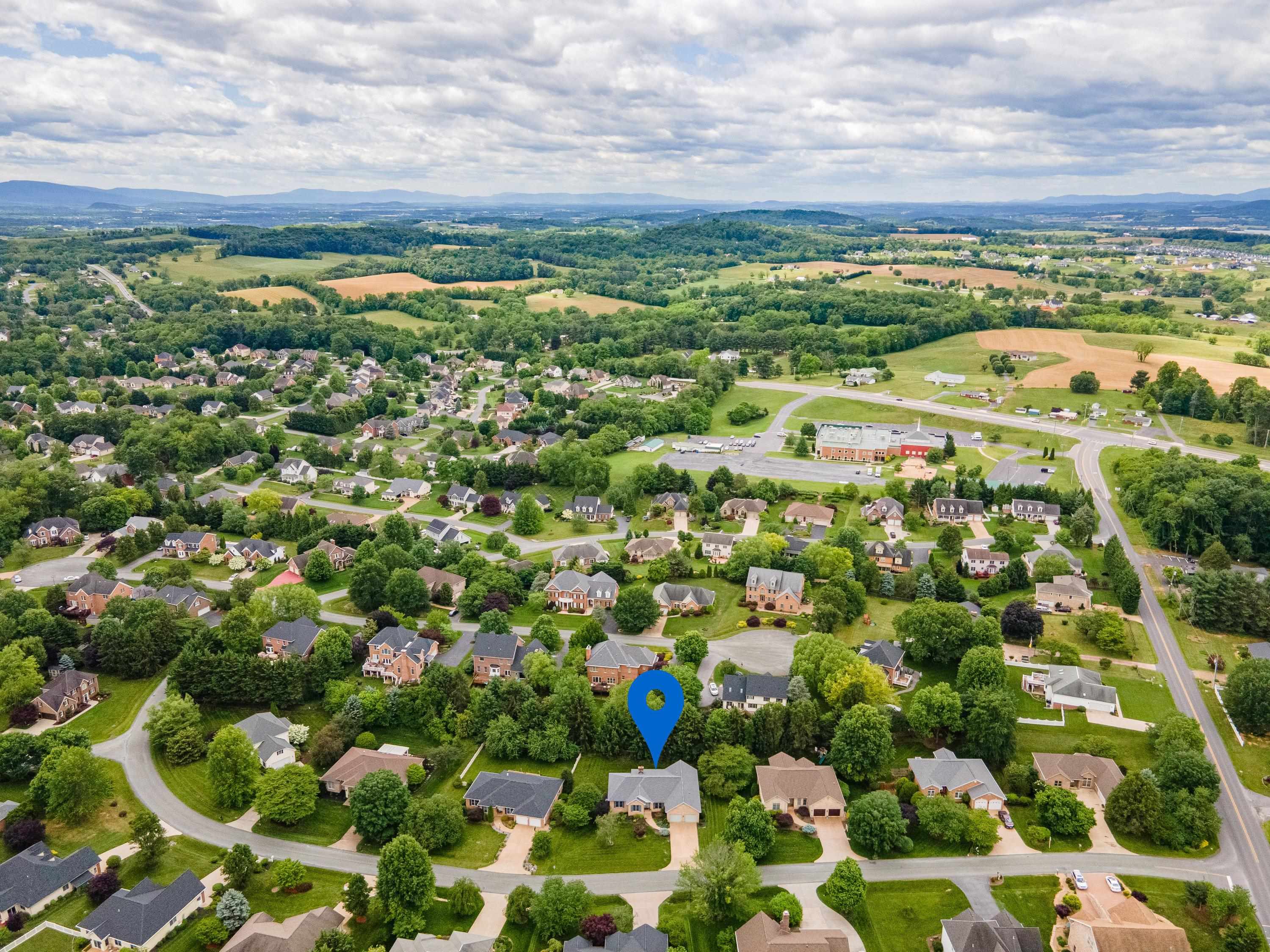The aerial view highlights the spacious lot this home is located on, the mature landscaping surrounding the home, and the Barrington subdivision.