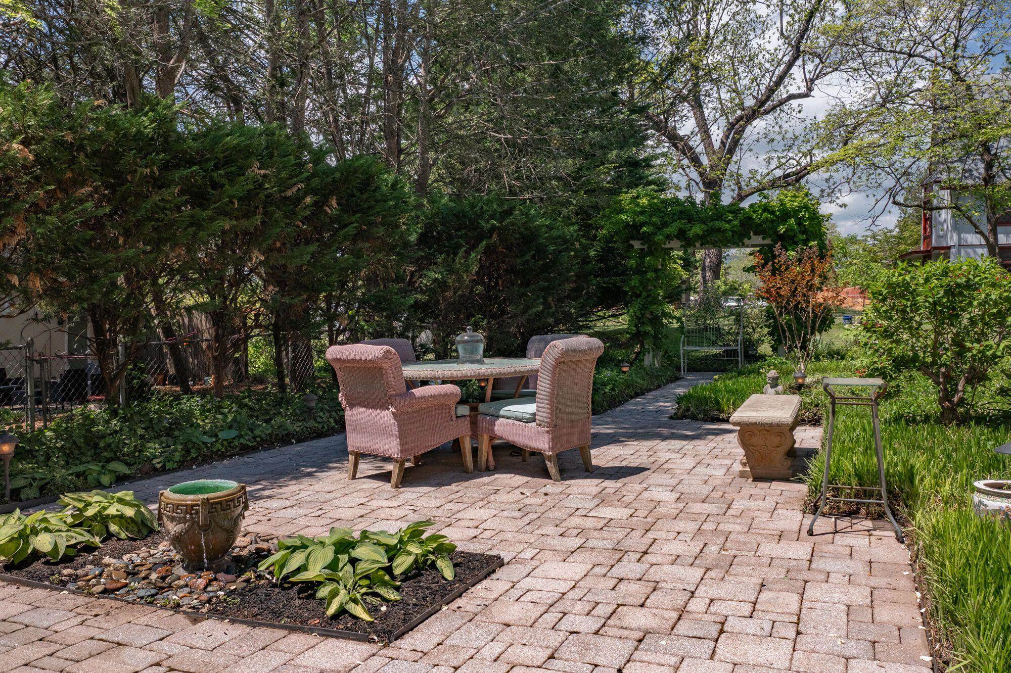 Come outdoors and enjoy the patio and fire pit, and the vine-covered trellis.