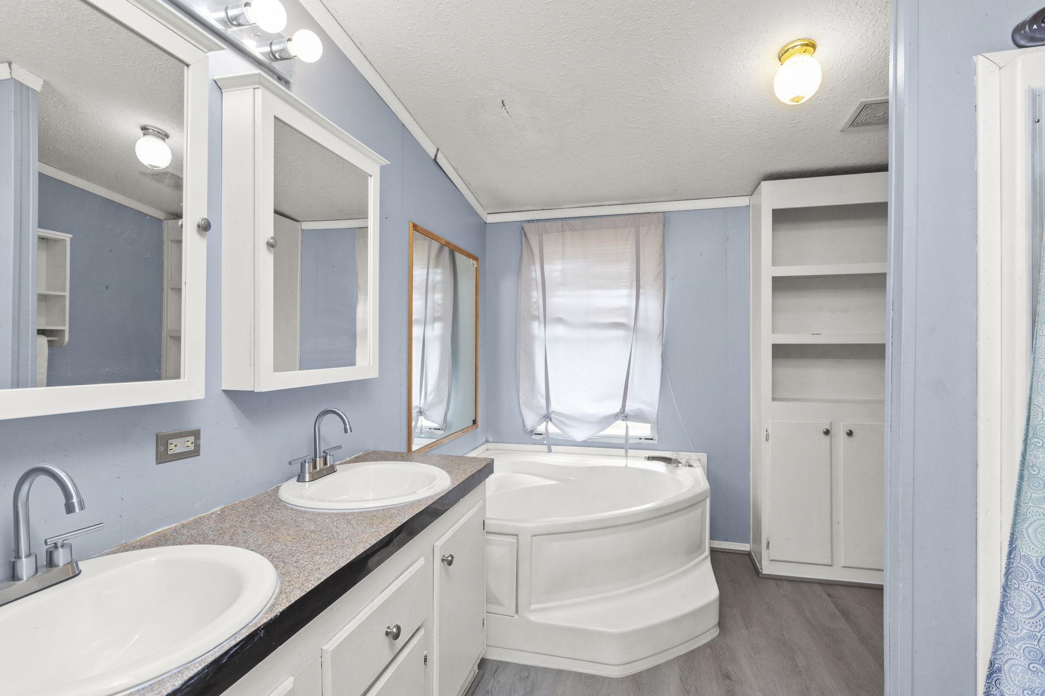 with garden tub, walk in shower and double sink vanity.