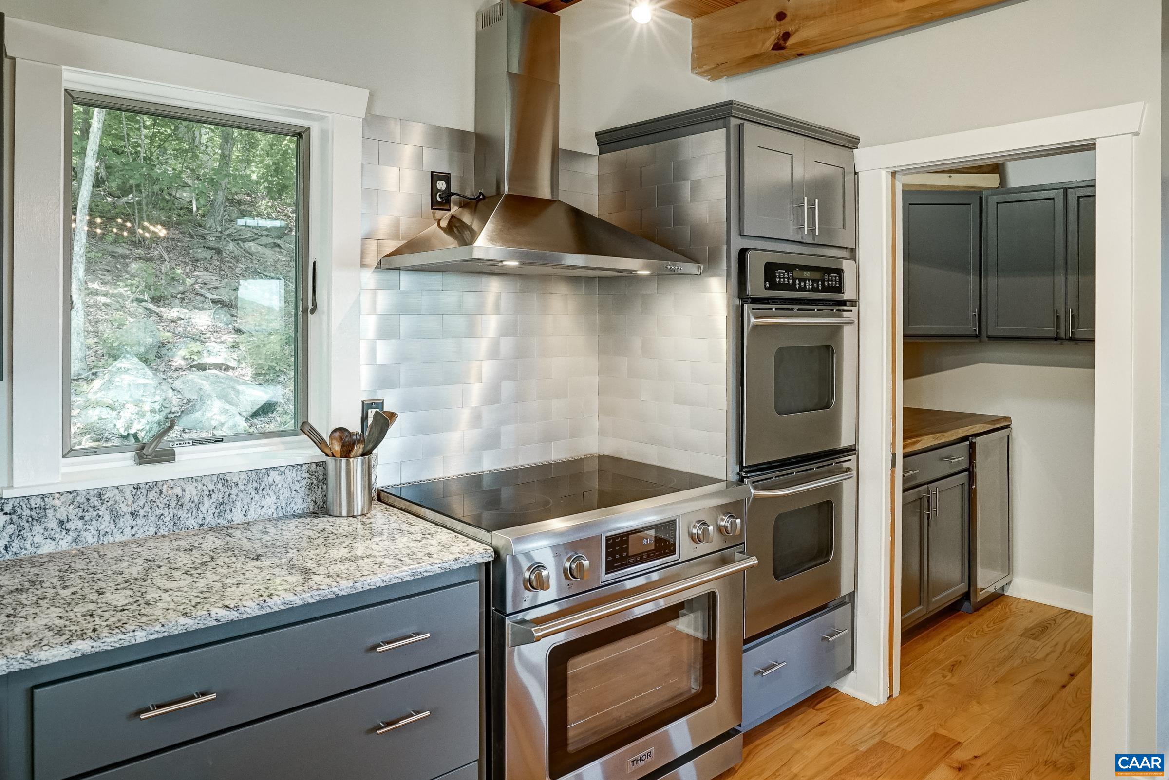 Range with double wall ovens are a bakers dream! Butlers pantry features live-edge countertops and a second wine cooler.