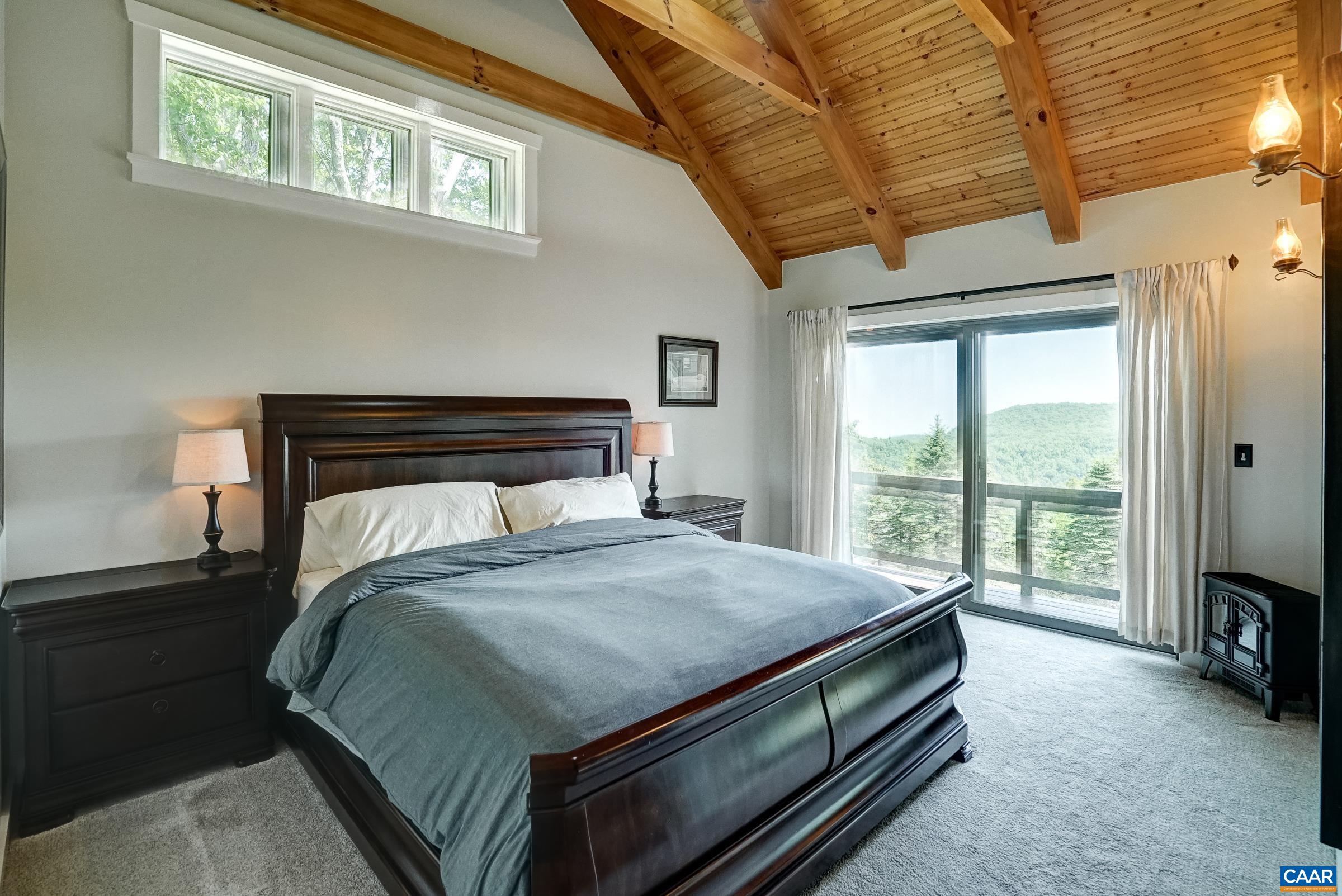 Main level primary suite boasts a private balcony and stunning ensuite bathroom.