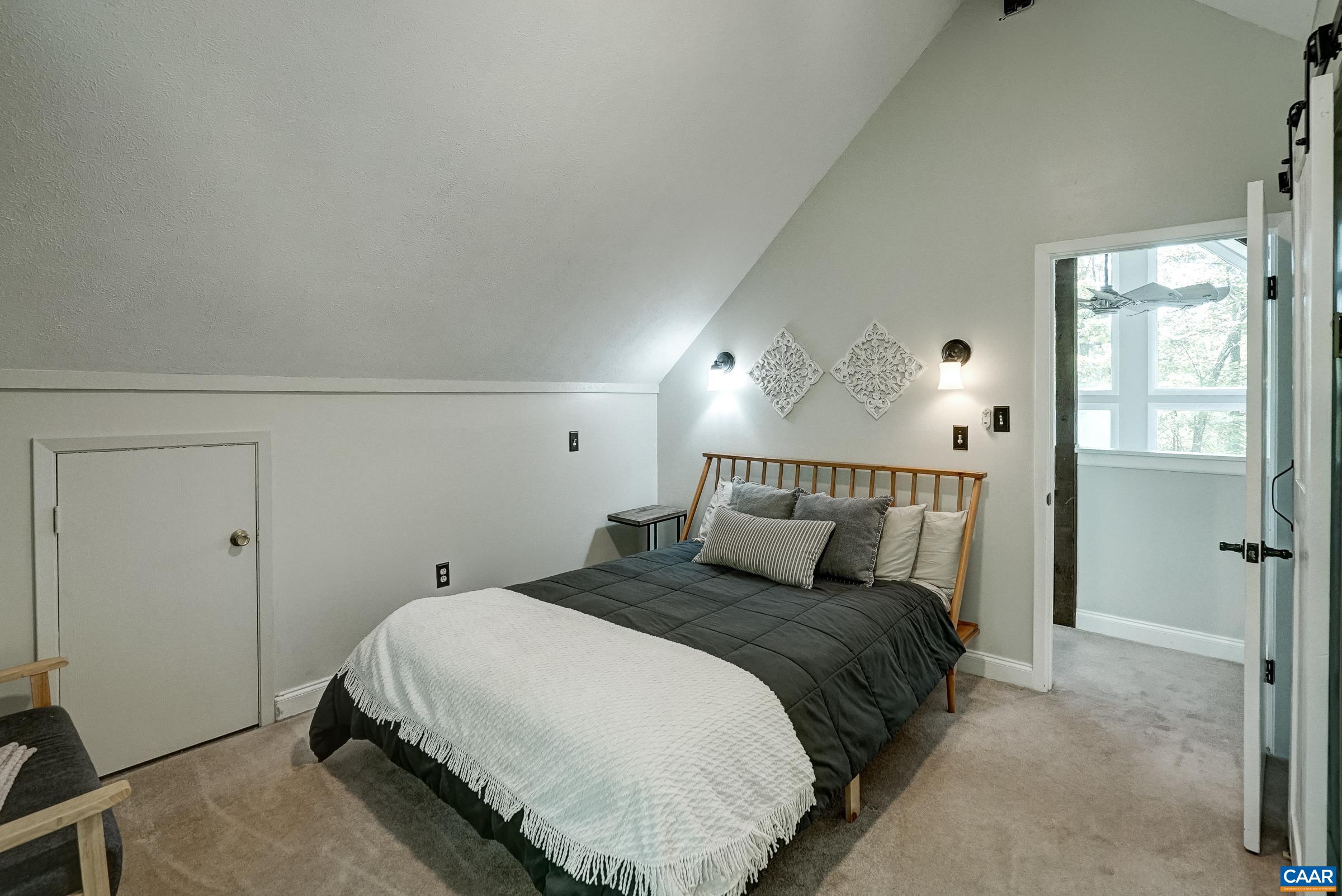 Primary bedroom on third floor features ensuite bathroom with sliding barn door.