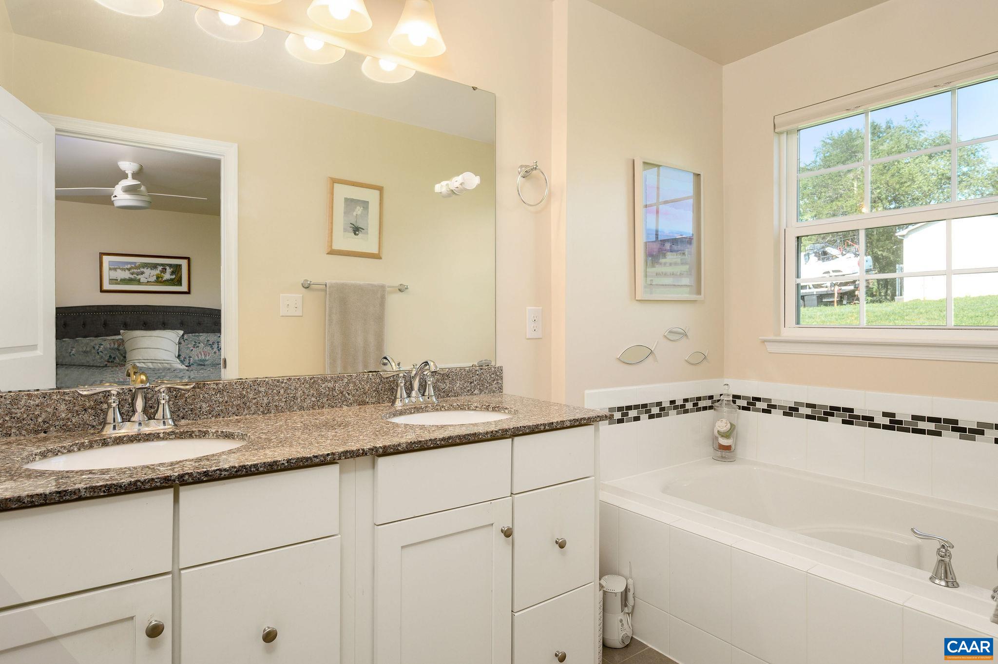 Primary bath with large soaking tubd and ual sinks with granite countertops.