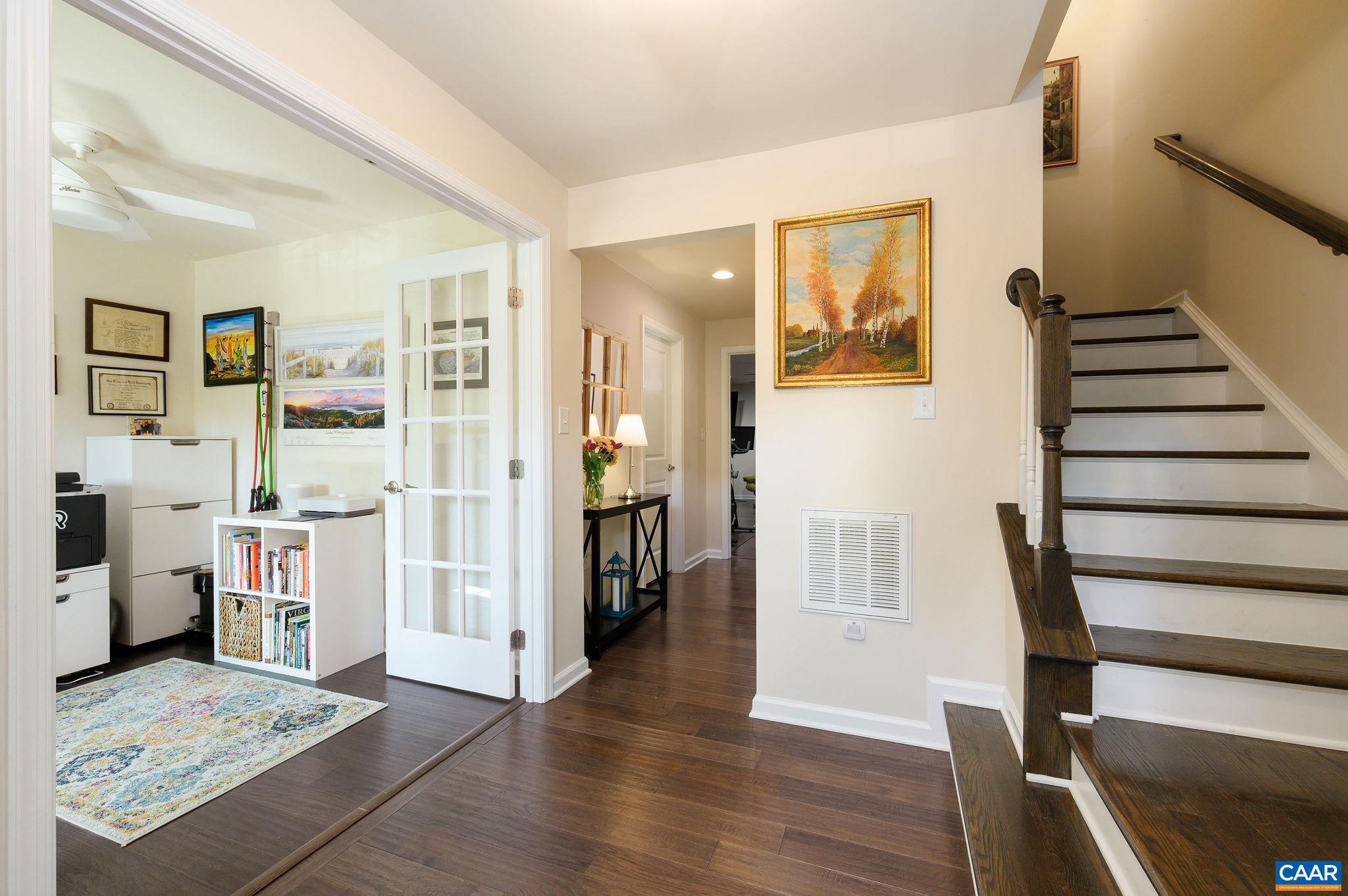 Entry level foyer with hardwood flooring, coat closet, and powder room.