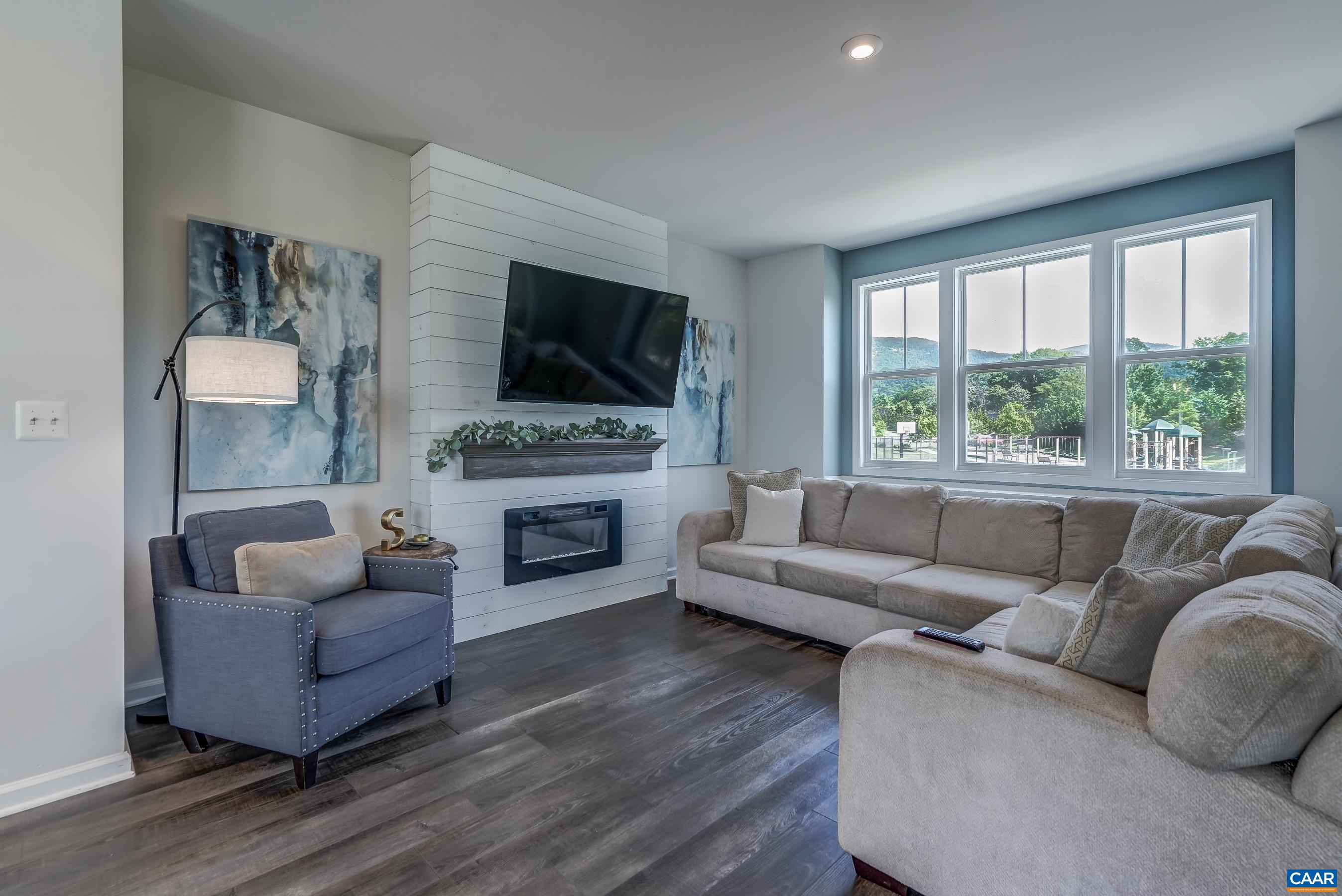 great room features custom-built ship lap accent feature with electric fireplace.