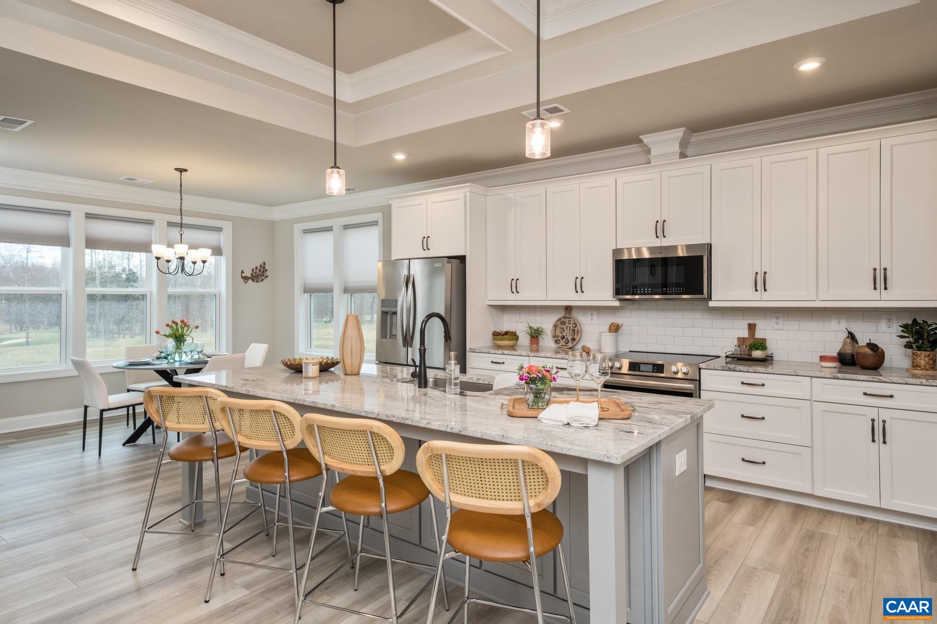 Upgraded Luxury Vinyl Plank continues from the living room to the kitchen.  The large kitchen island features plenty of seating, pendant lighting, and upgraded granite.