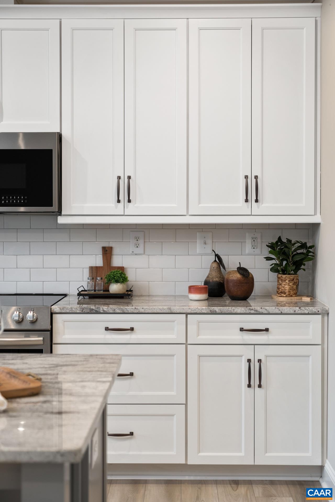 Kitchen cabinetry and upgraded granite countertops and backsplash.
