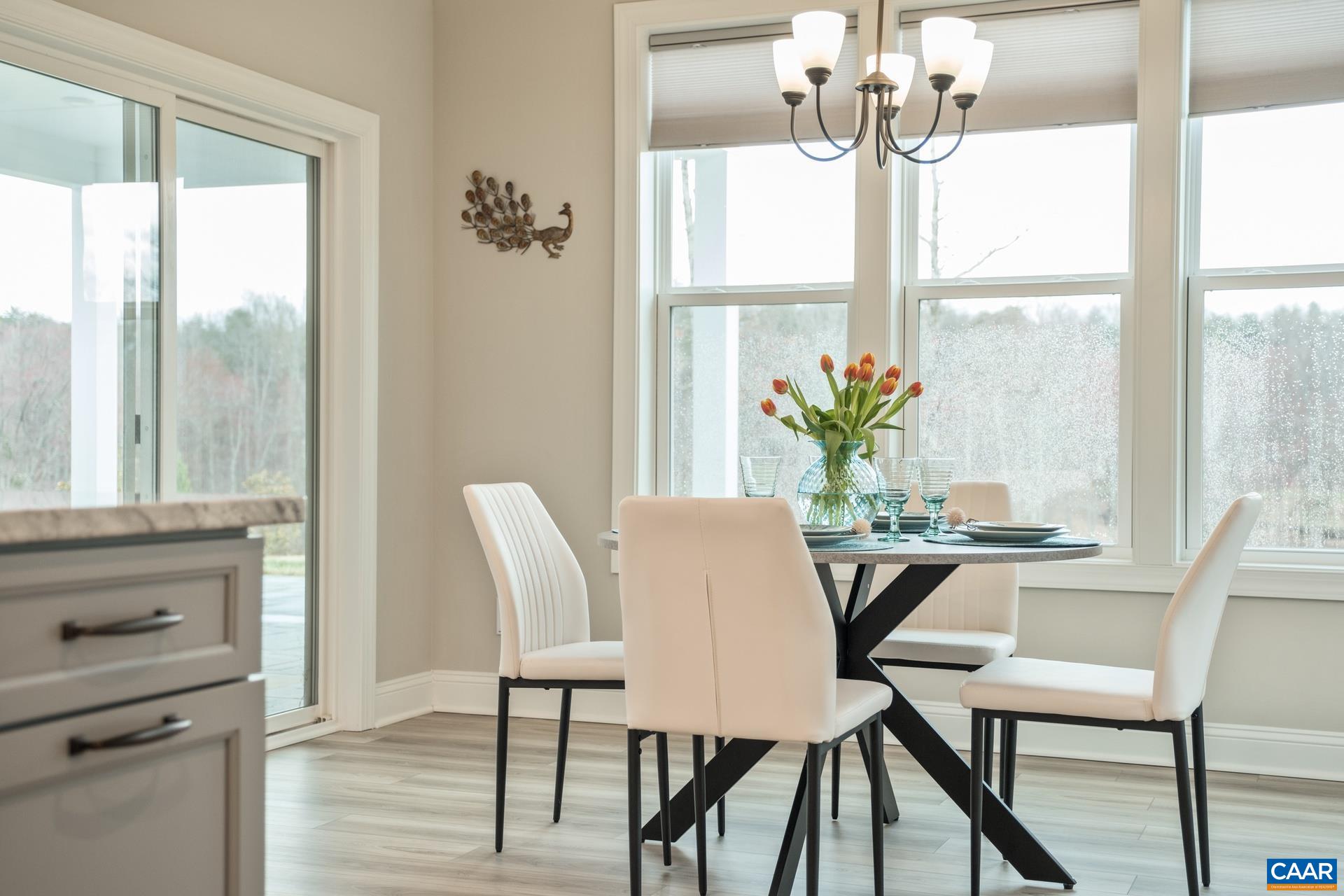 The brightly lit dining room features crown molding and a triple window overlooking the golf course.  Just off the dining room is the custom thermal bluestone patio and covered porch.