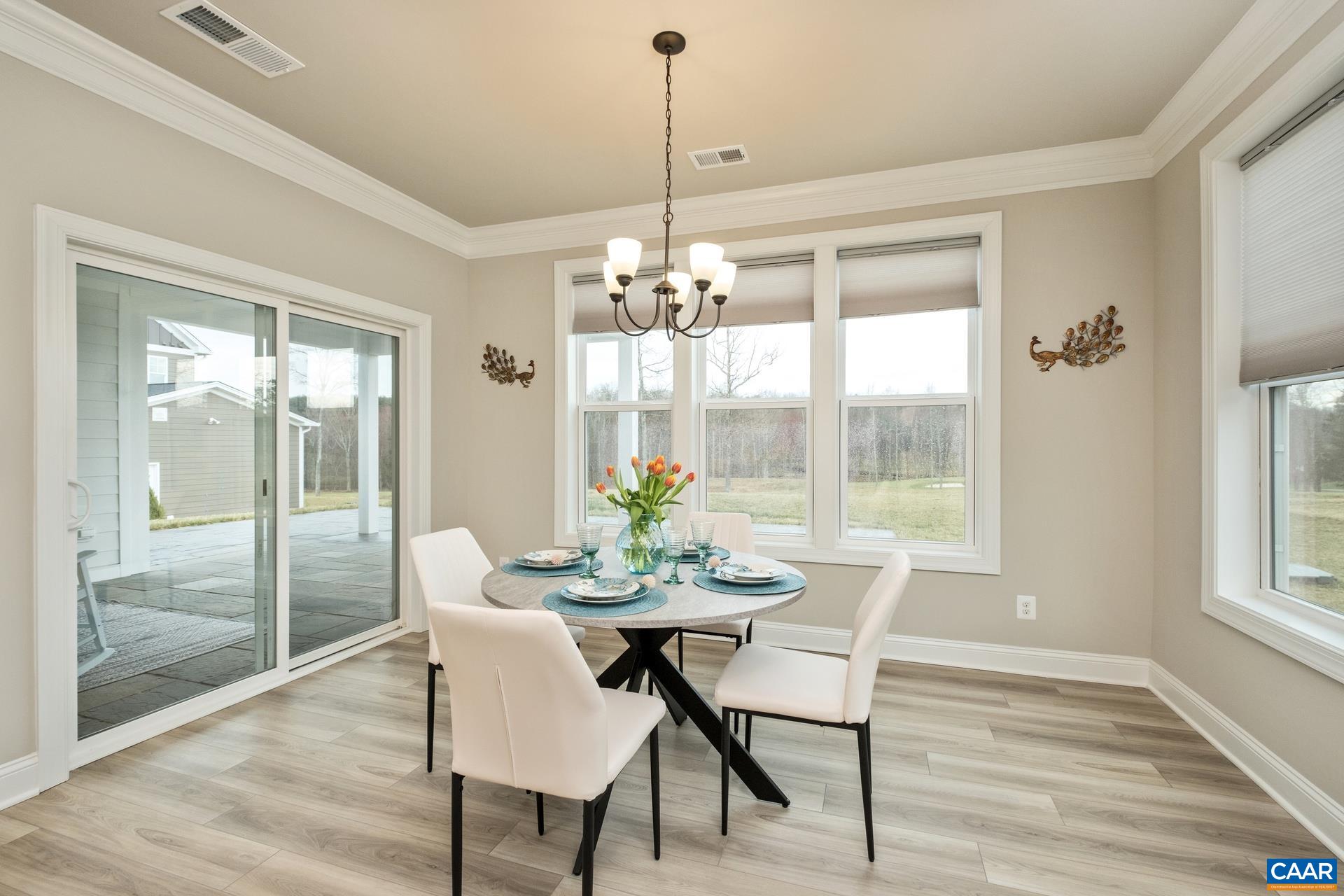The brightly lit dining room features crown molding and a triple window overlooking the golf course.  Just off the dining room is the custom thermal bluestone patio and covered porch.