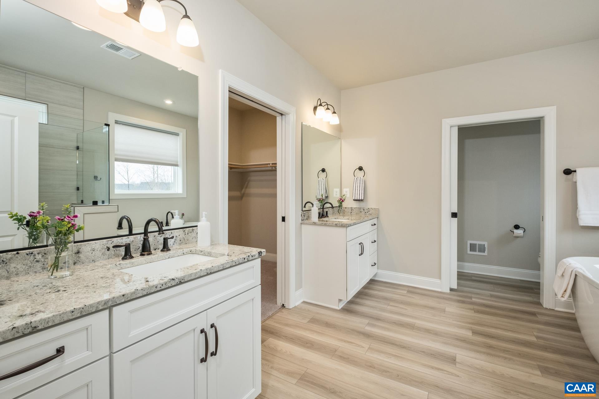 The ensuite bathroom features upgraded granite, upgraded LVP, and upgraded tile.   The bathroom also features a pocket door at the water closet and a garden tub.