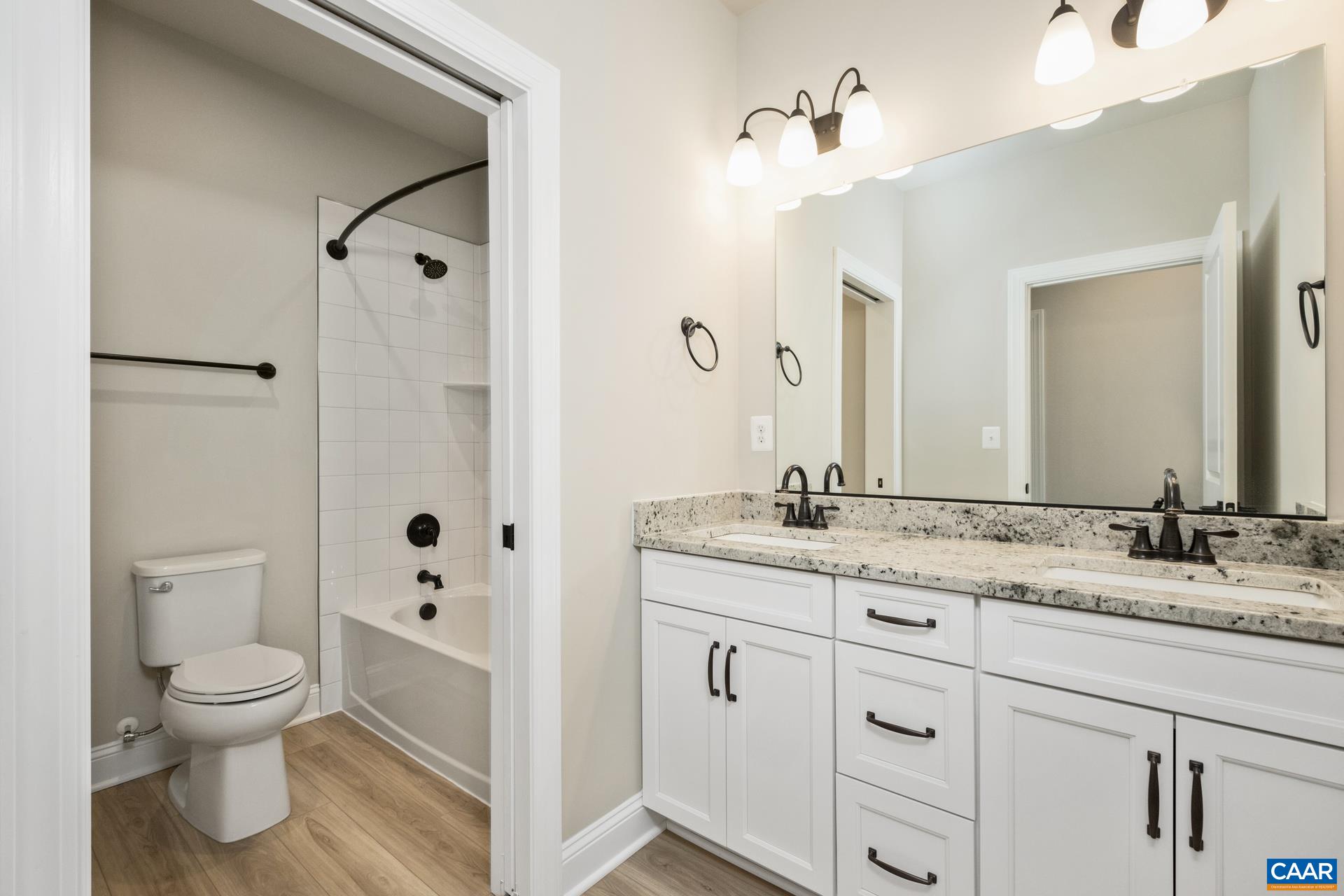 This full bathroom is located in the hall near bedrooms 2-3, and features upgraded granite.