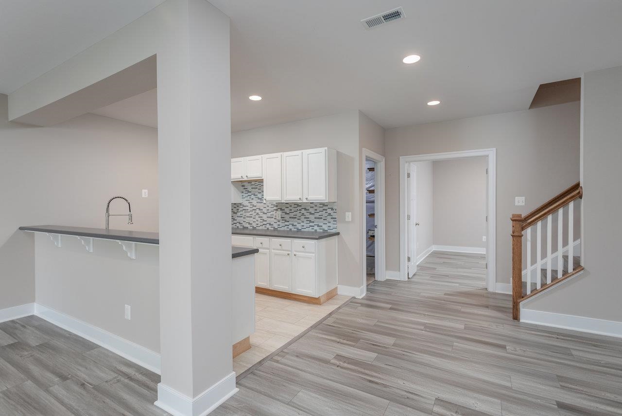 This incredible space features luxury vinyl  plank flooring, a wonderful rec room with a wet bar/kitchenette that includes an under the counter refrigerator