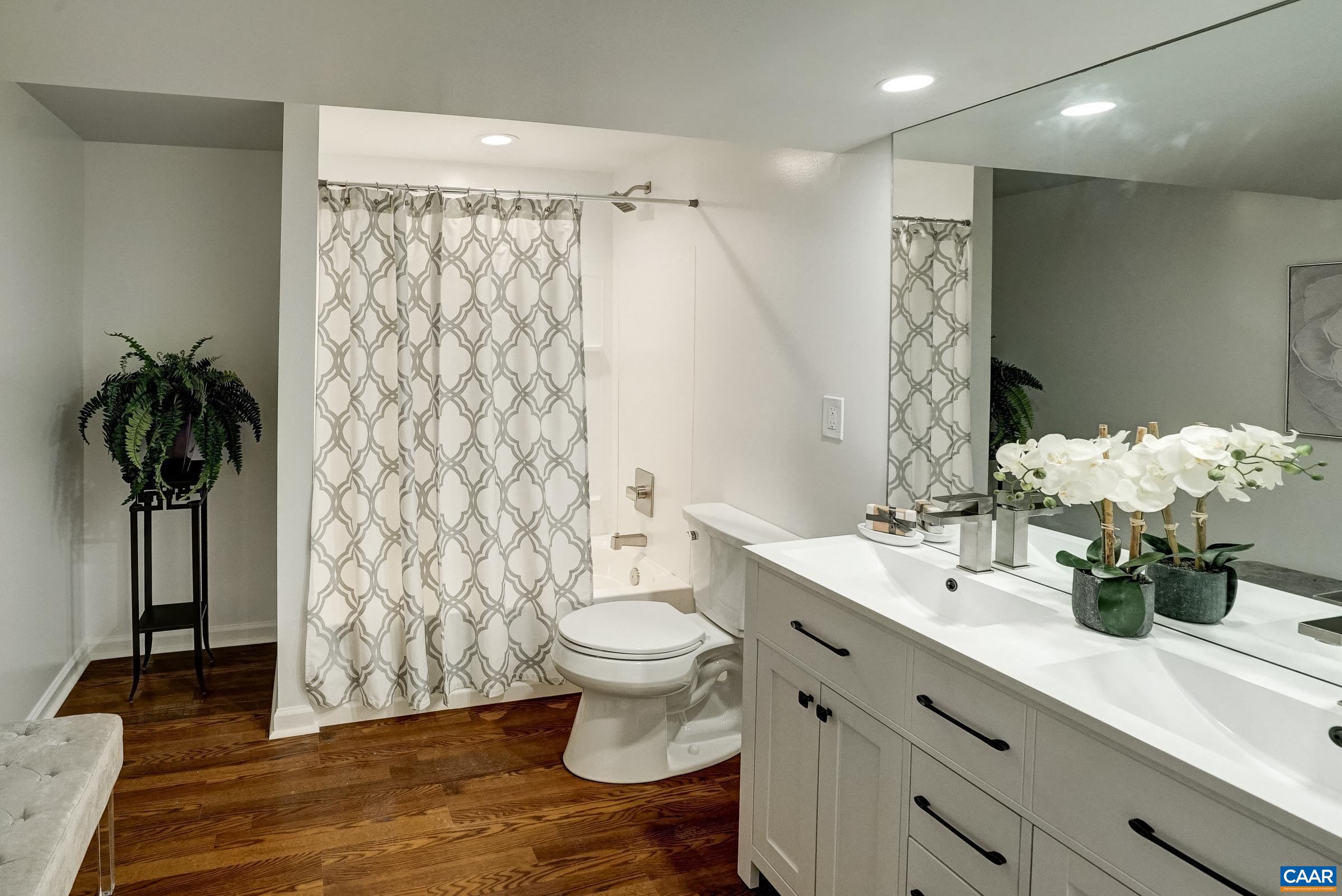 New full bathroom in the basement with tub and double sink vanity.