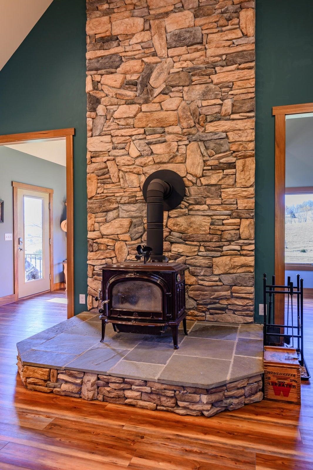 Wood stove fireplace with picturesque rock chimney -- a centerpiece in the open floor plan.