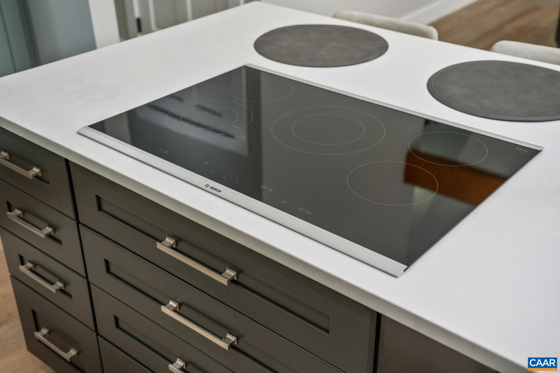 The kitchen island features a Bosch cooktop, and upgraded cabinetry/drawers with soft close and stackable storage areas.