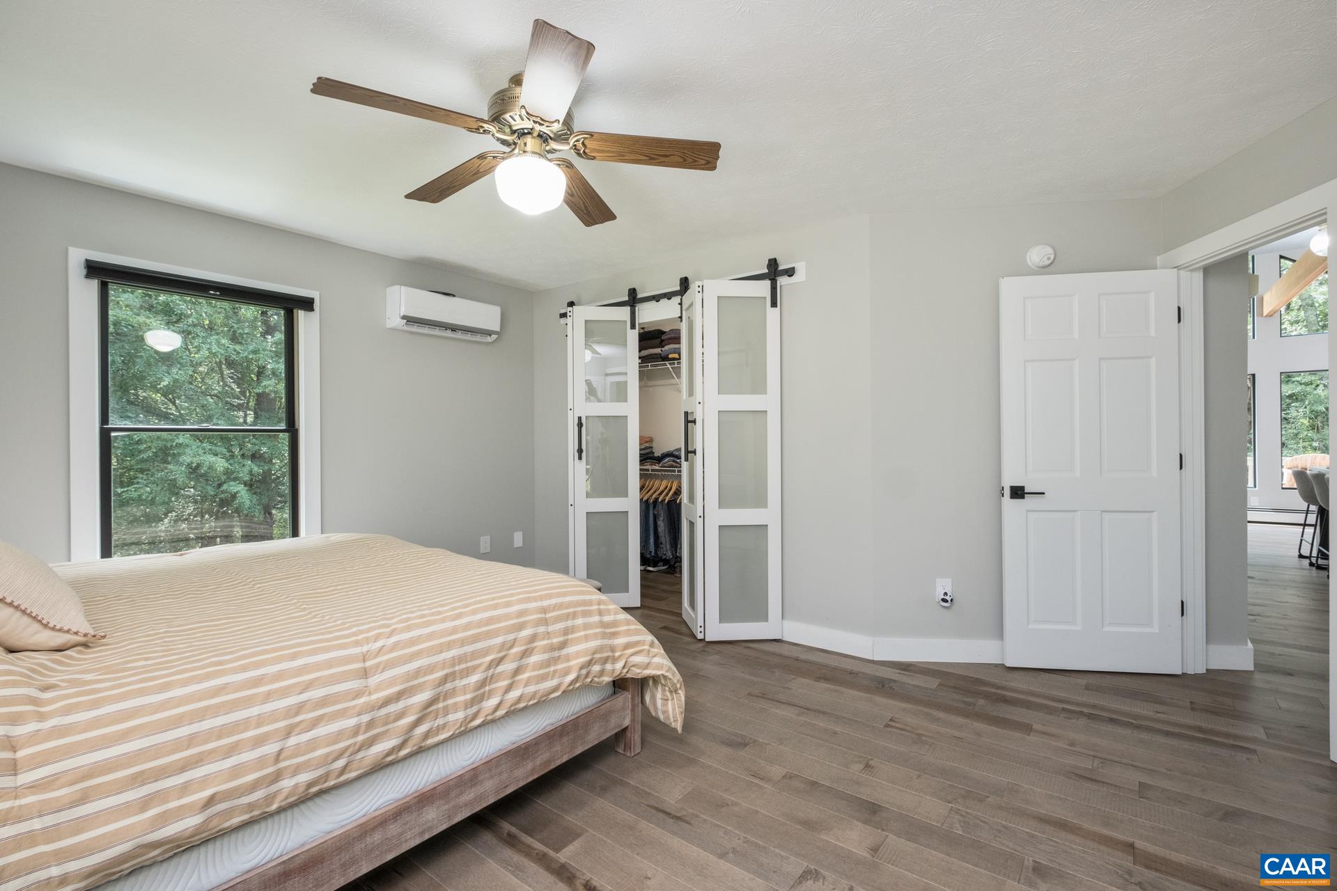 The primary suite is on the main level, and features solid maple flooring and barn door style closet doors.