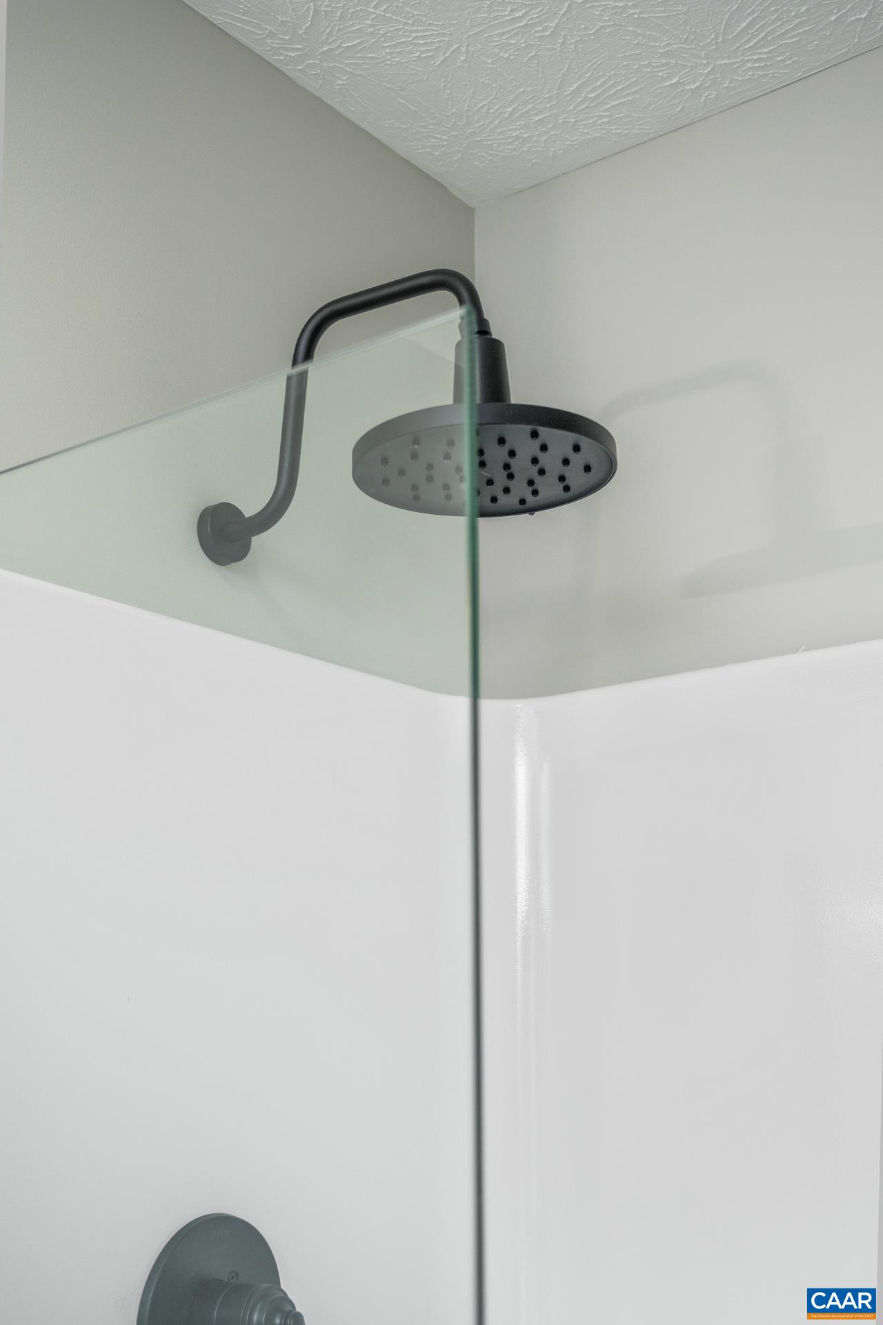 The shower features new fixtures and a glass enclosure.