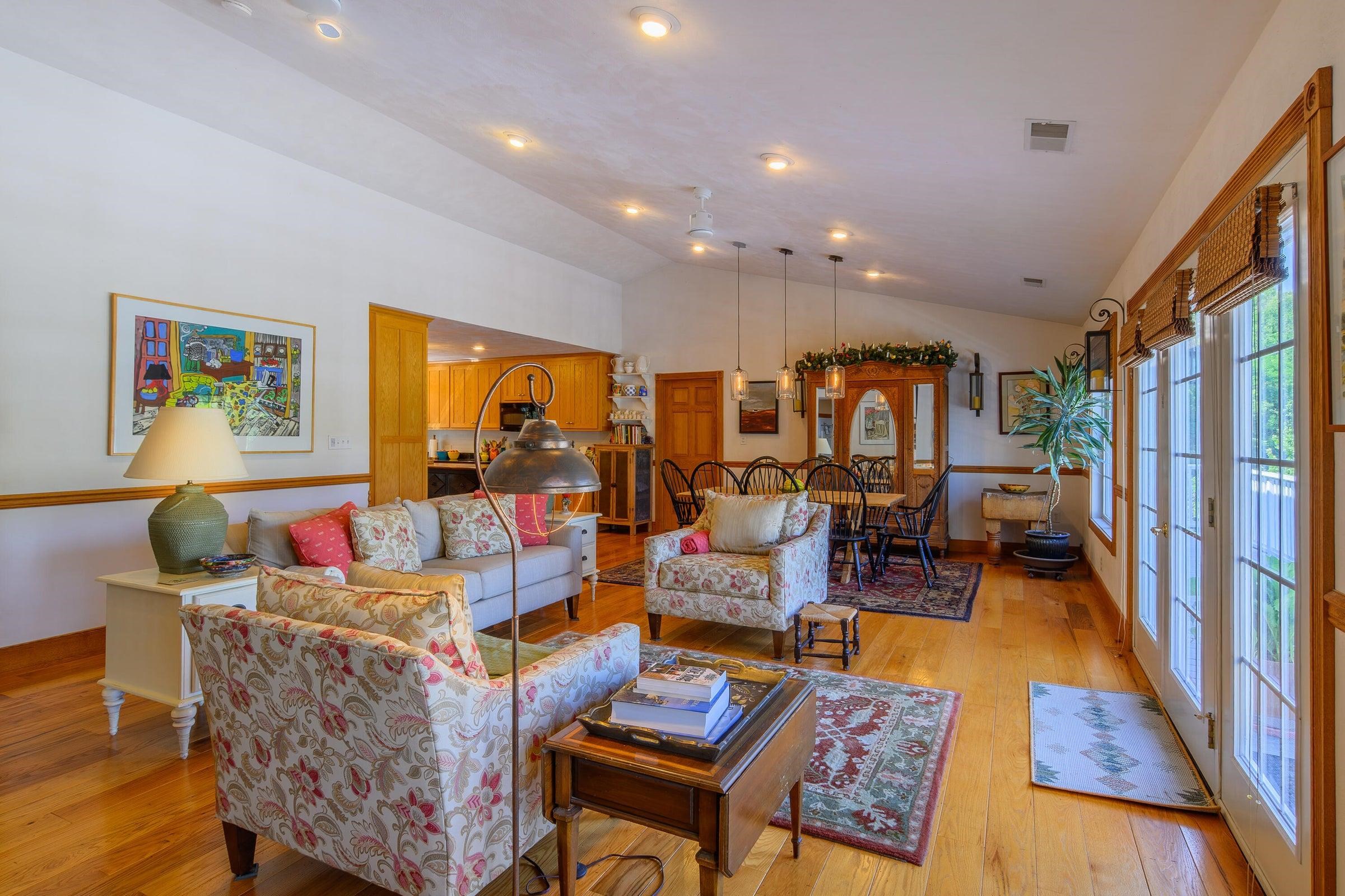 This view shows the expansive open floor plan: kitchen, dining area, living room; doors to balcony.