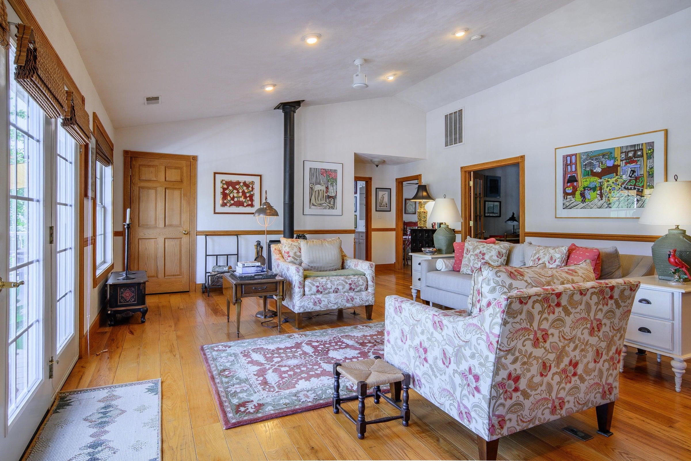 Lots of light in the Living Room. A wood stove resides across the room.
