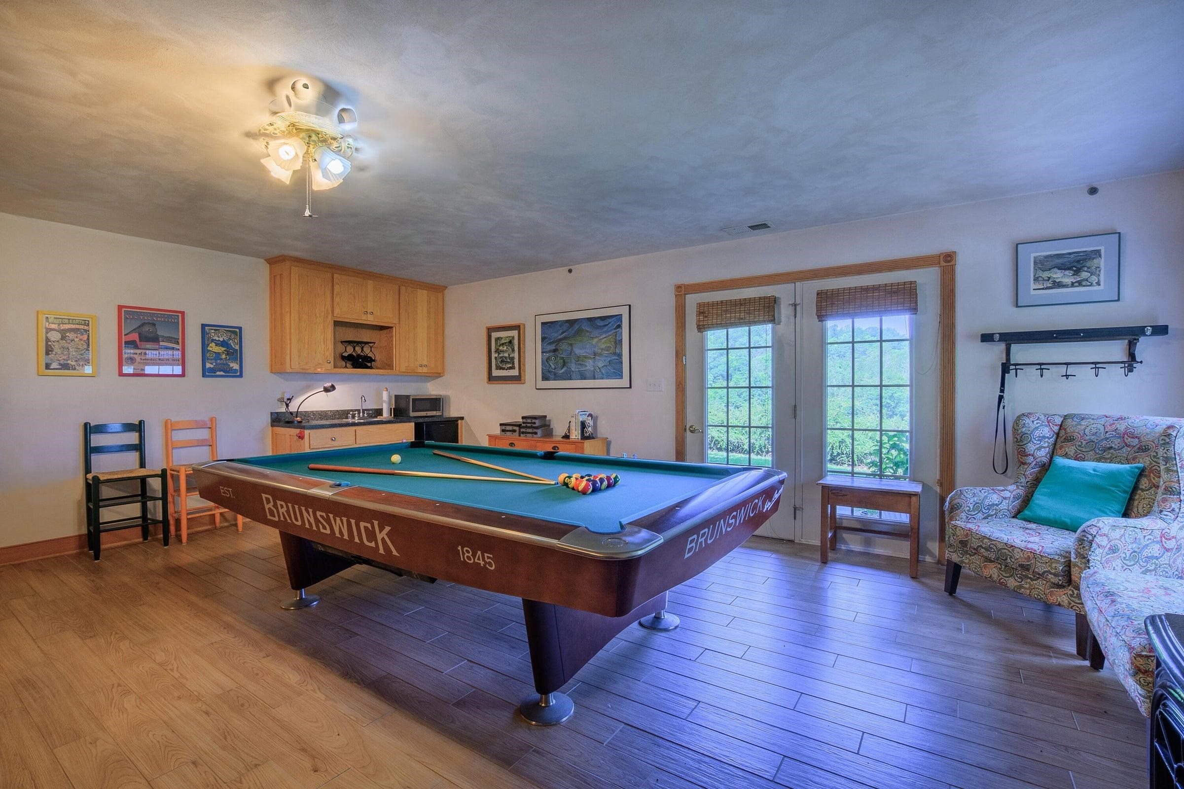 In the corner is a kitchenette with a refrigerator, microwave, a sink and cabinets.