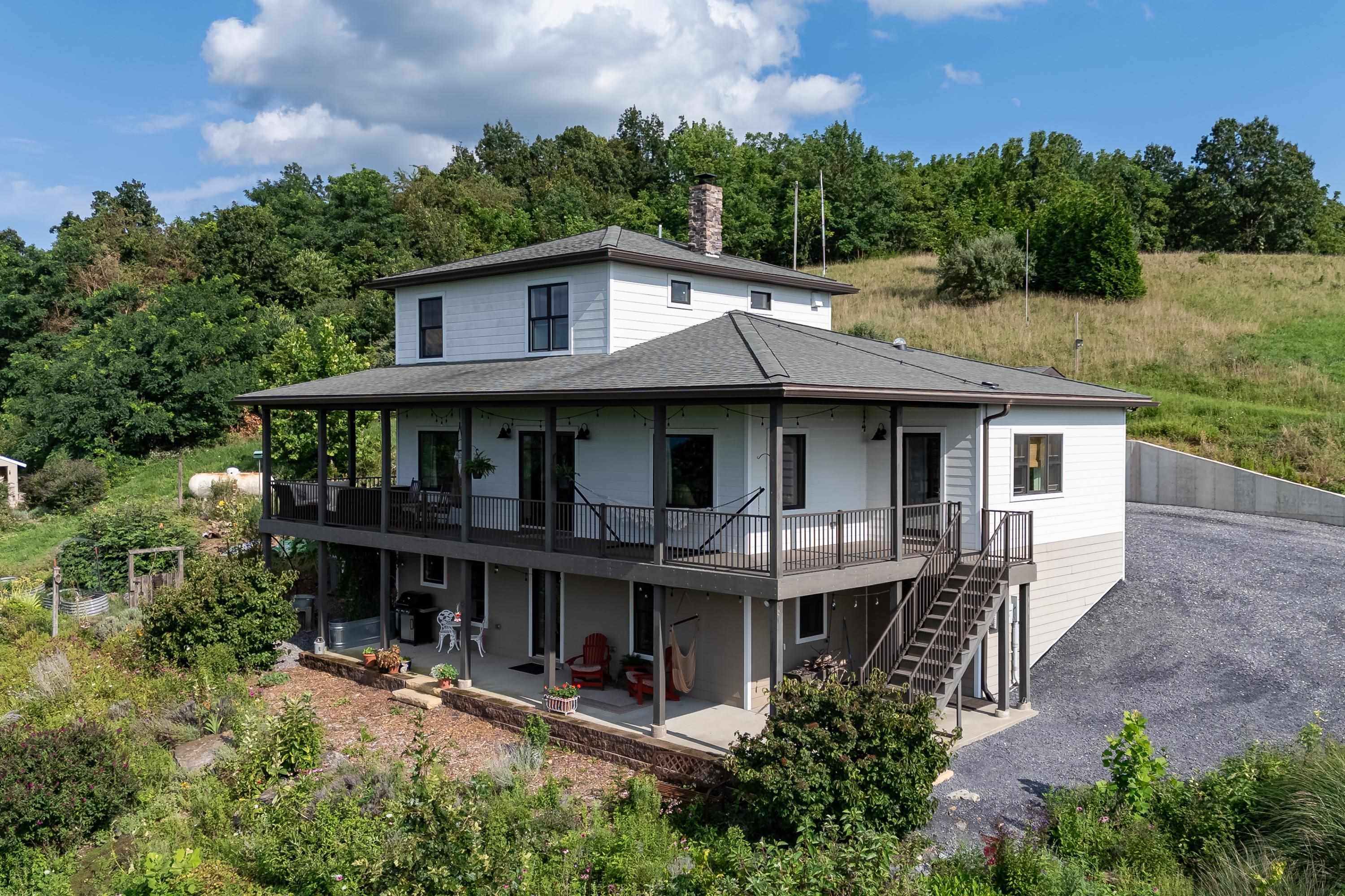 The front view of the beautiful home located at 11180 Daphna Road.  This front view highlights the large parking area, spacious covered from porch and patio, hardy plank siding, and very spacious lot with outstanding views!