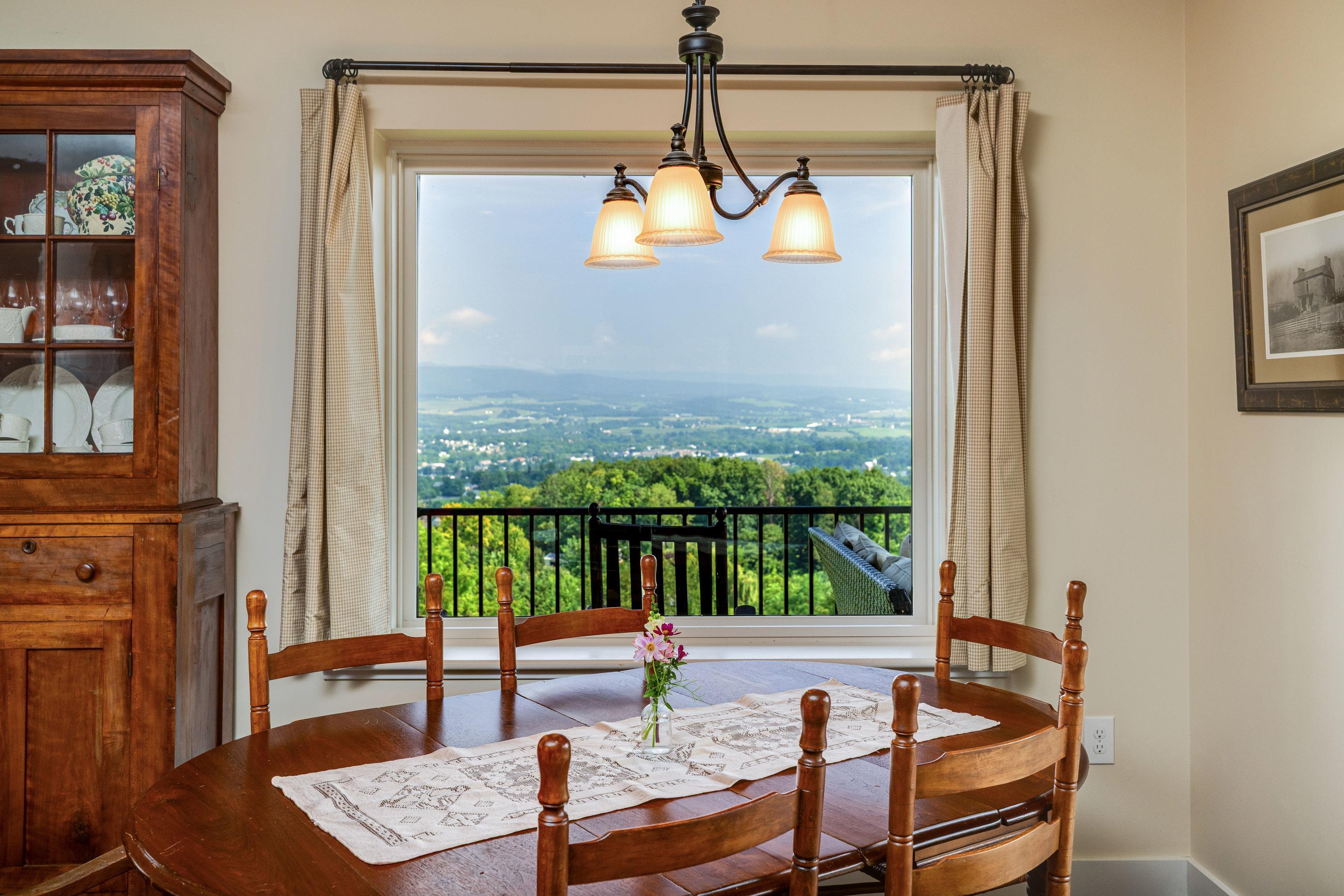 Directly off the kitchen is a large dining area.  This space features a chandelier, hardwood flooring, windows overlooking a view of the mountains, and plenty of space for a table and chairs set.