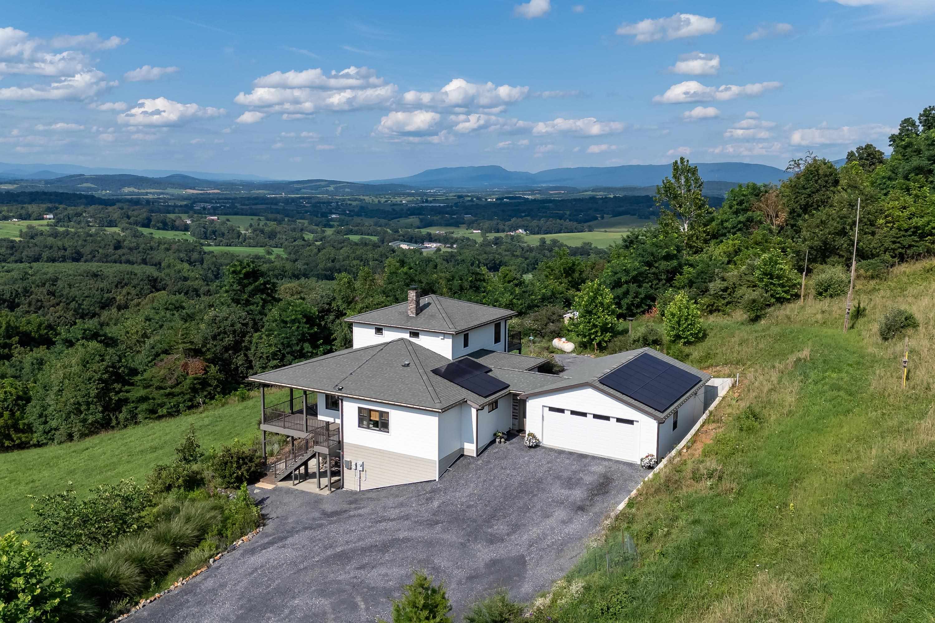 The aerial view shows off the beauty of the views surrounding the home.  From the porch you can view the mountains, valley, and overlook the spacious lot surrounding the home.