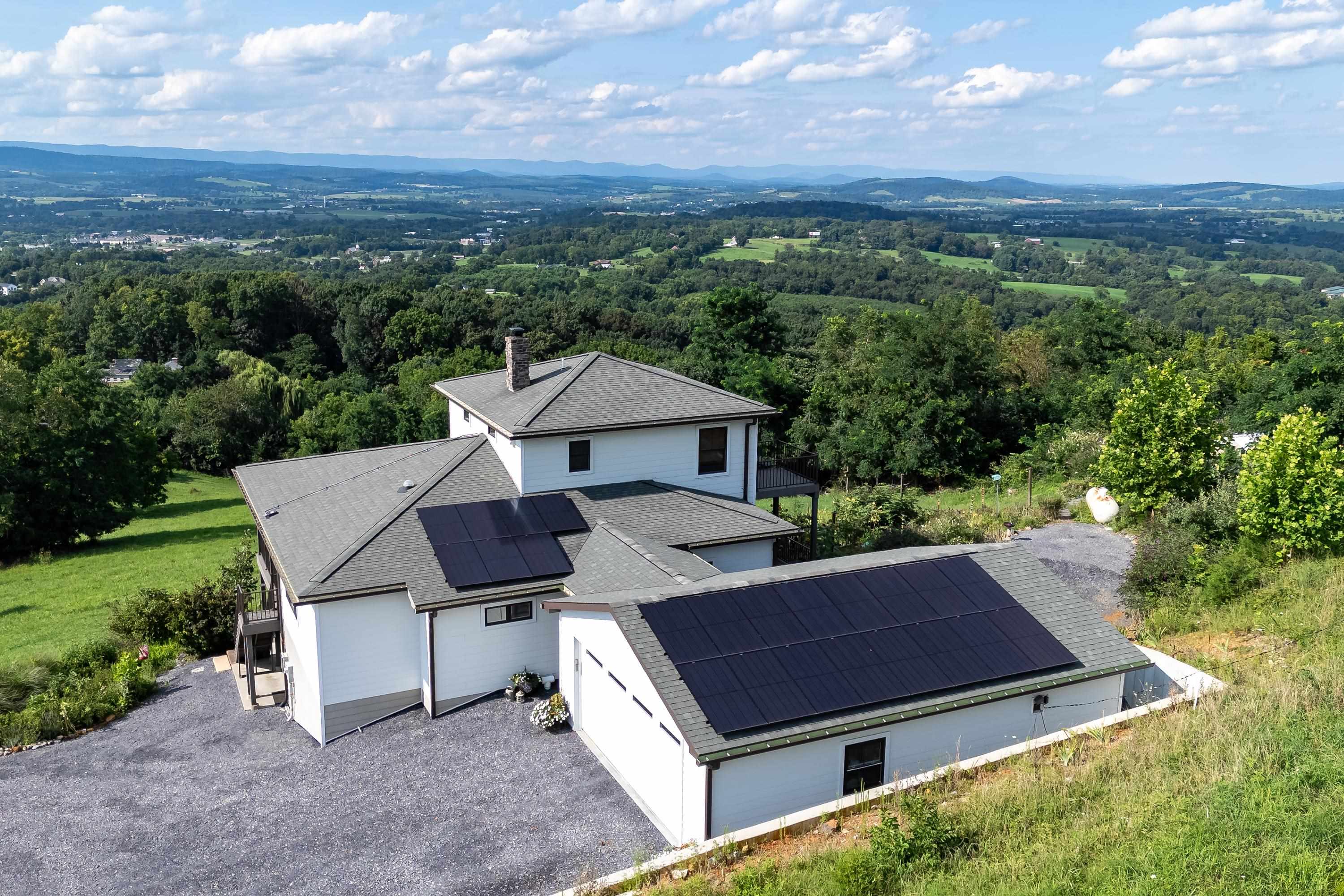 The aerial view shows off the beauty of the views surrounding the home.  From the porch you can view the mountains, valley, and overlook the spacious lot surrounding the home.
