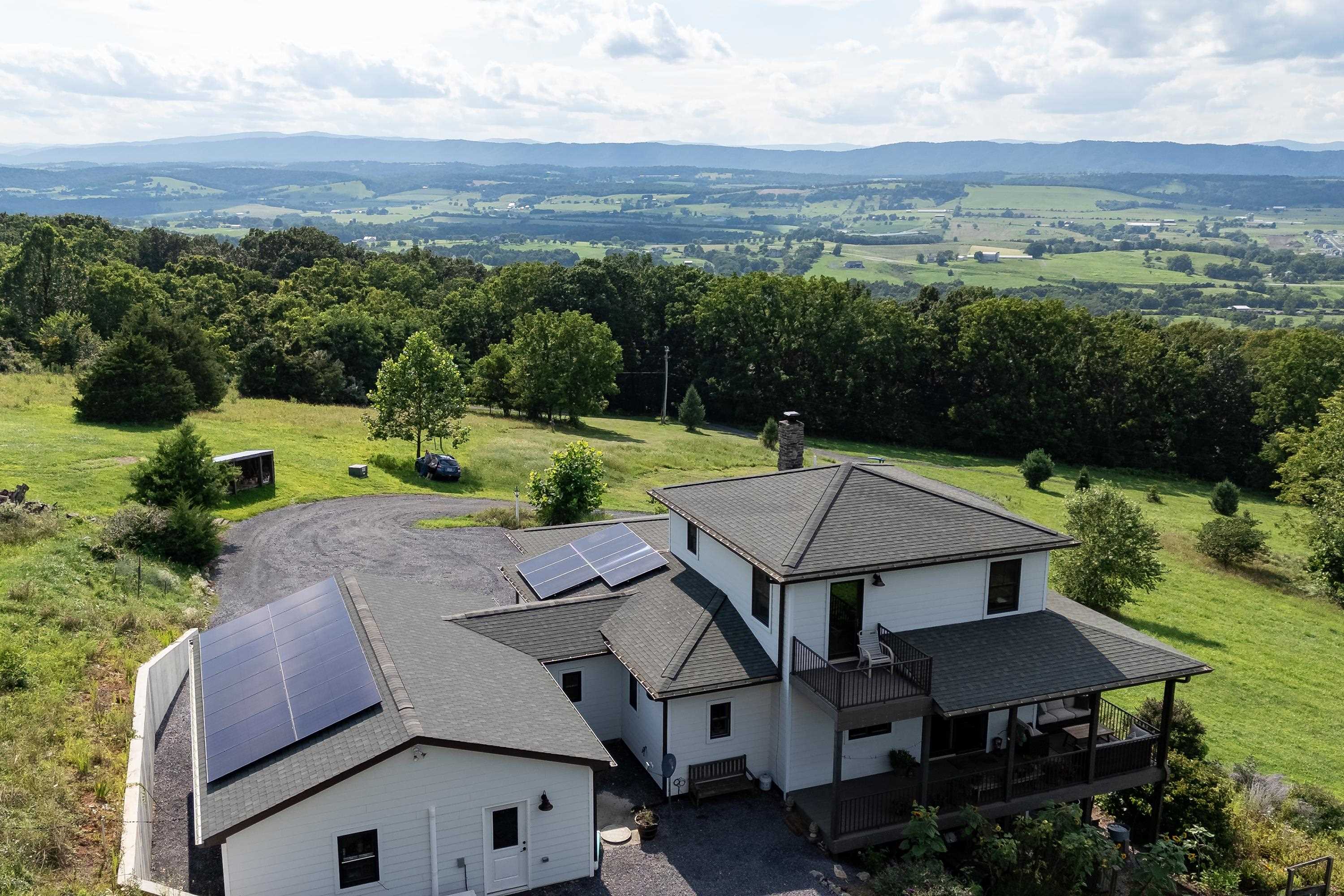 The aerial view shows off the beauty of the views surrounding the home.  From the porch you can view the mountains, valley, and overlook the spacious lot surrounding the home.