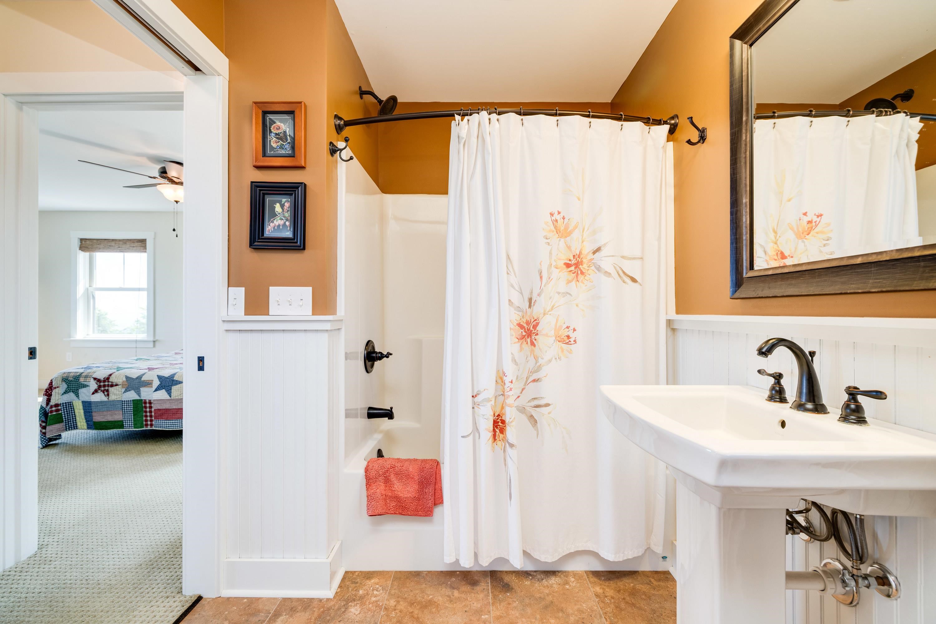 This full bathroom offers convenience to bedroom 2 and 3.  This bathroom features a pedastal sink and features a full bathtub/shower combination.