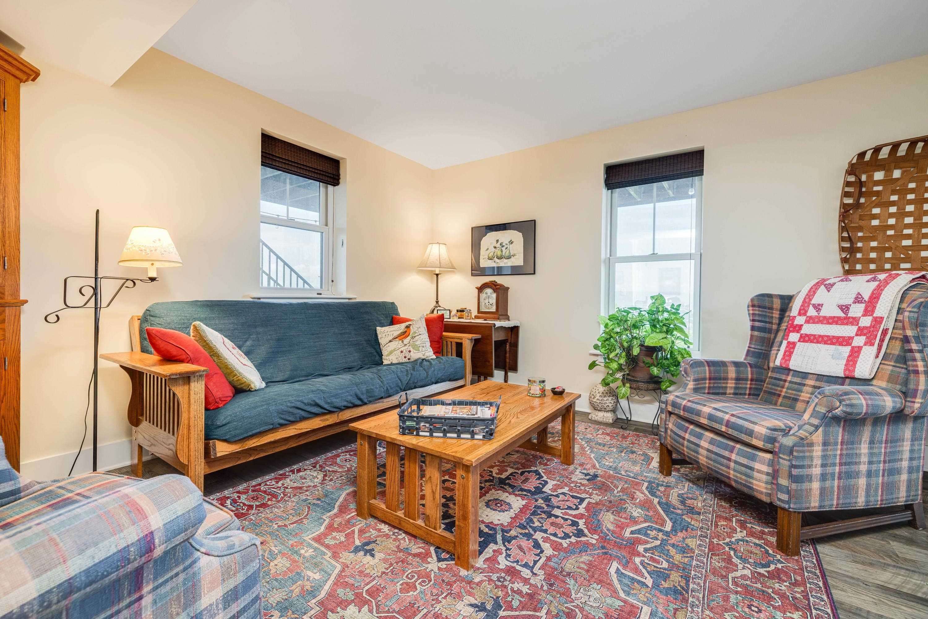 This large living room features a door leading to the covered patio, luxury vinyl plank flooring, multiple windows, and more!