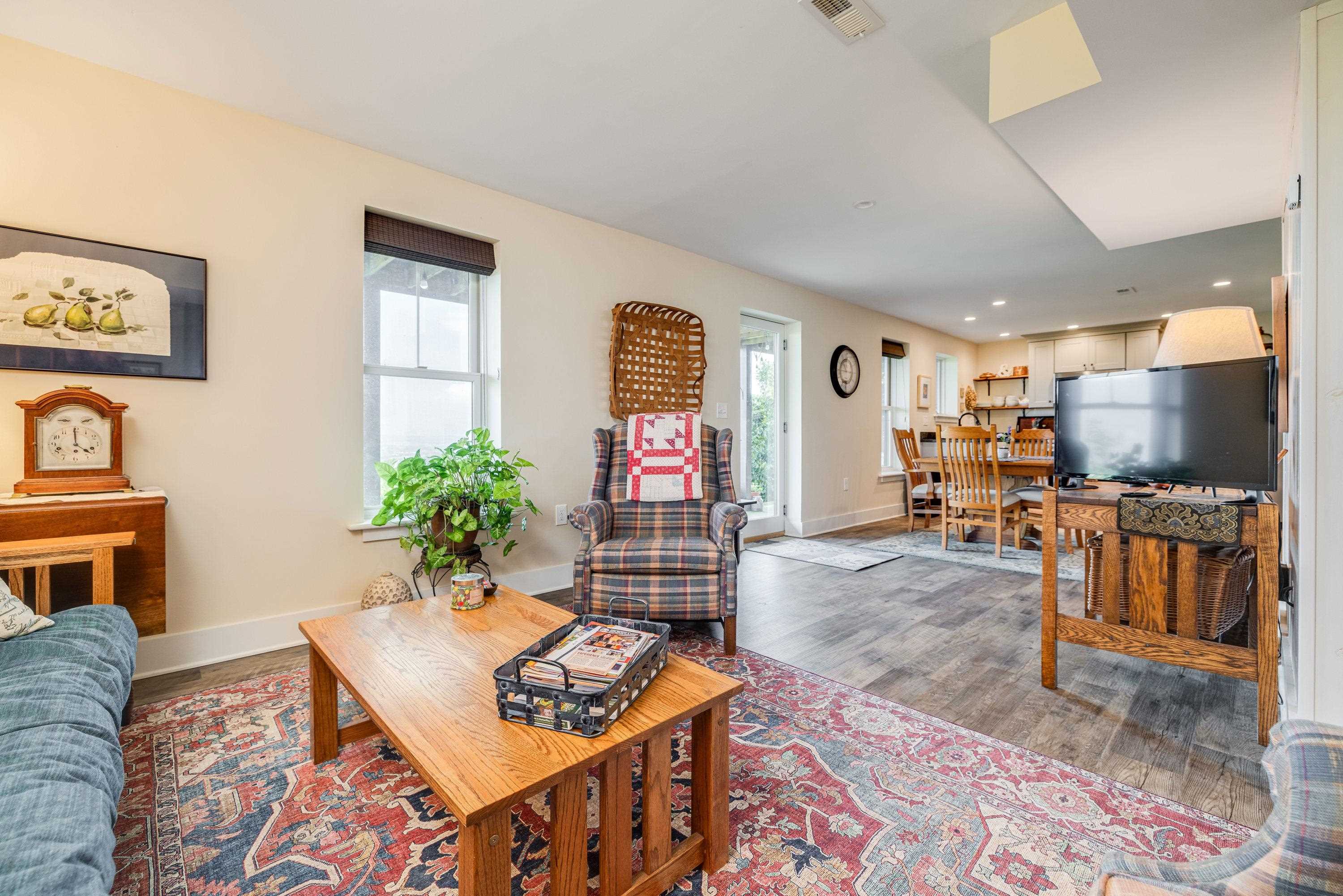 This large living room features a door leading to the covered patio, luxury vinyl plank flooring, multiple windows, and more!