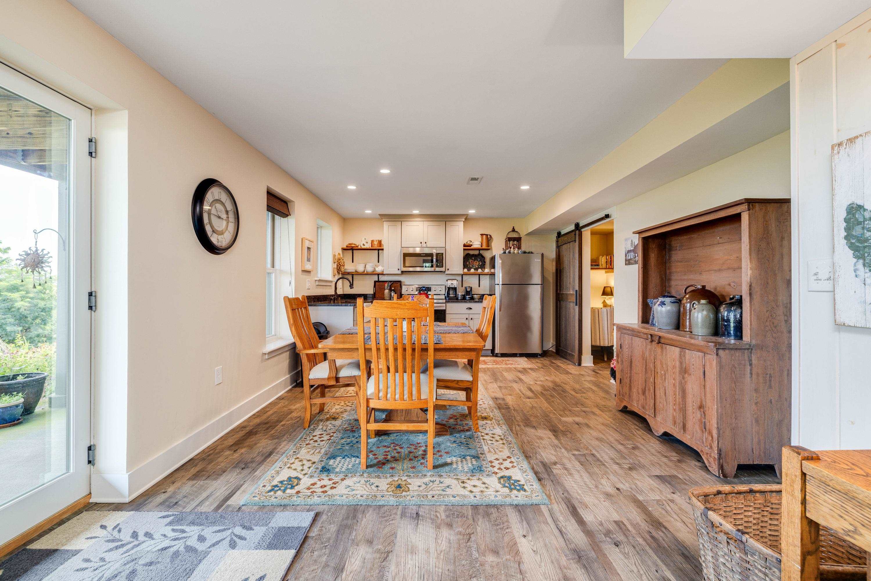 This large living room features a door leading to the covered patio, luxury vinyl plank flooring, multiple windows, and more!