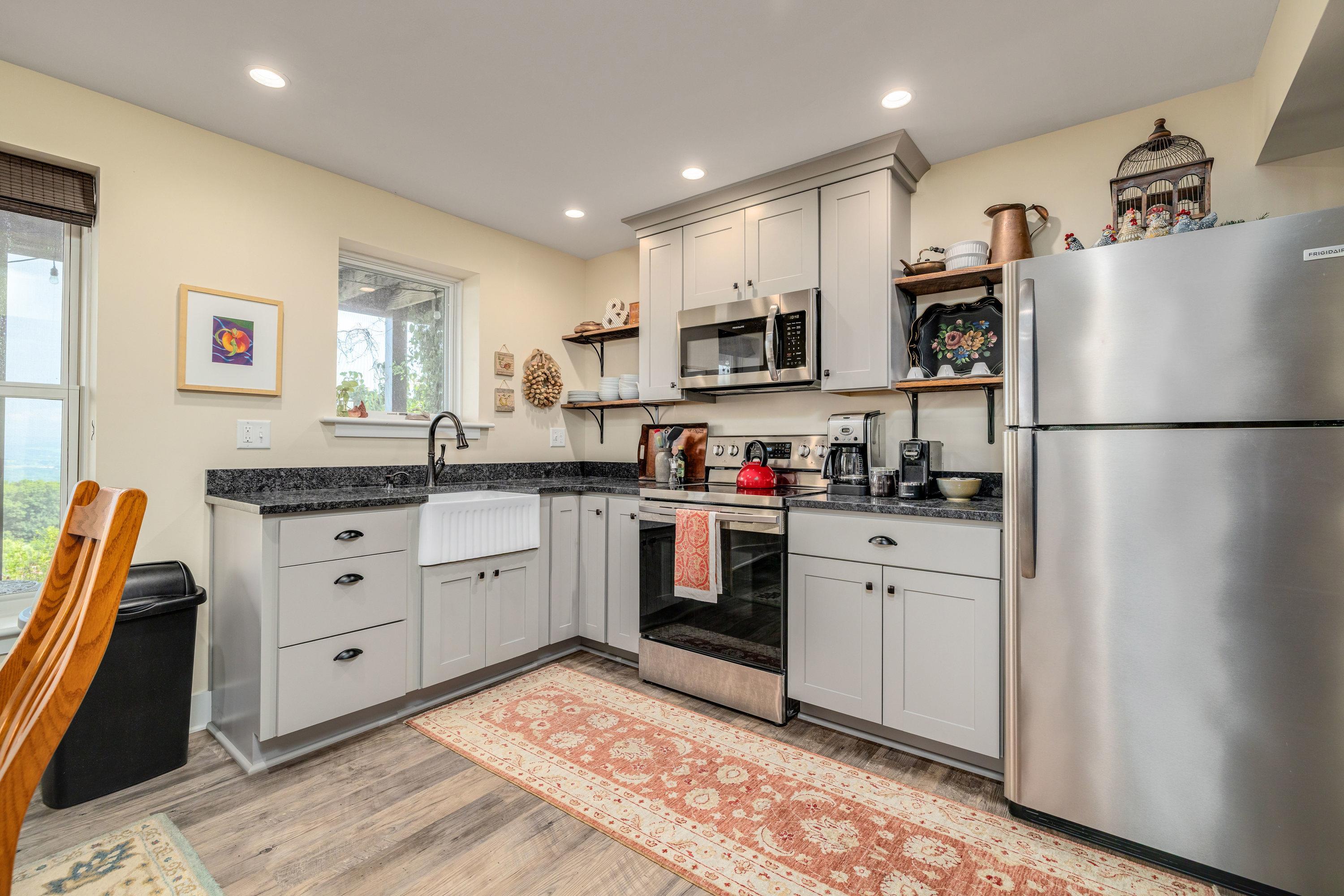 This second kitchen features wooden cabinetry throughout, luxury vinyl plank flooring, stainless steel appliances and much more!