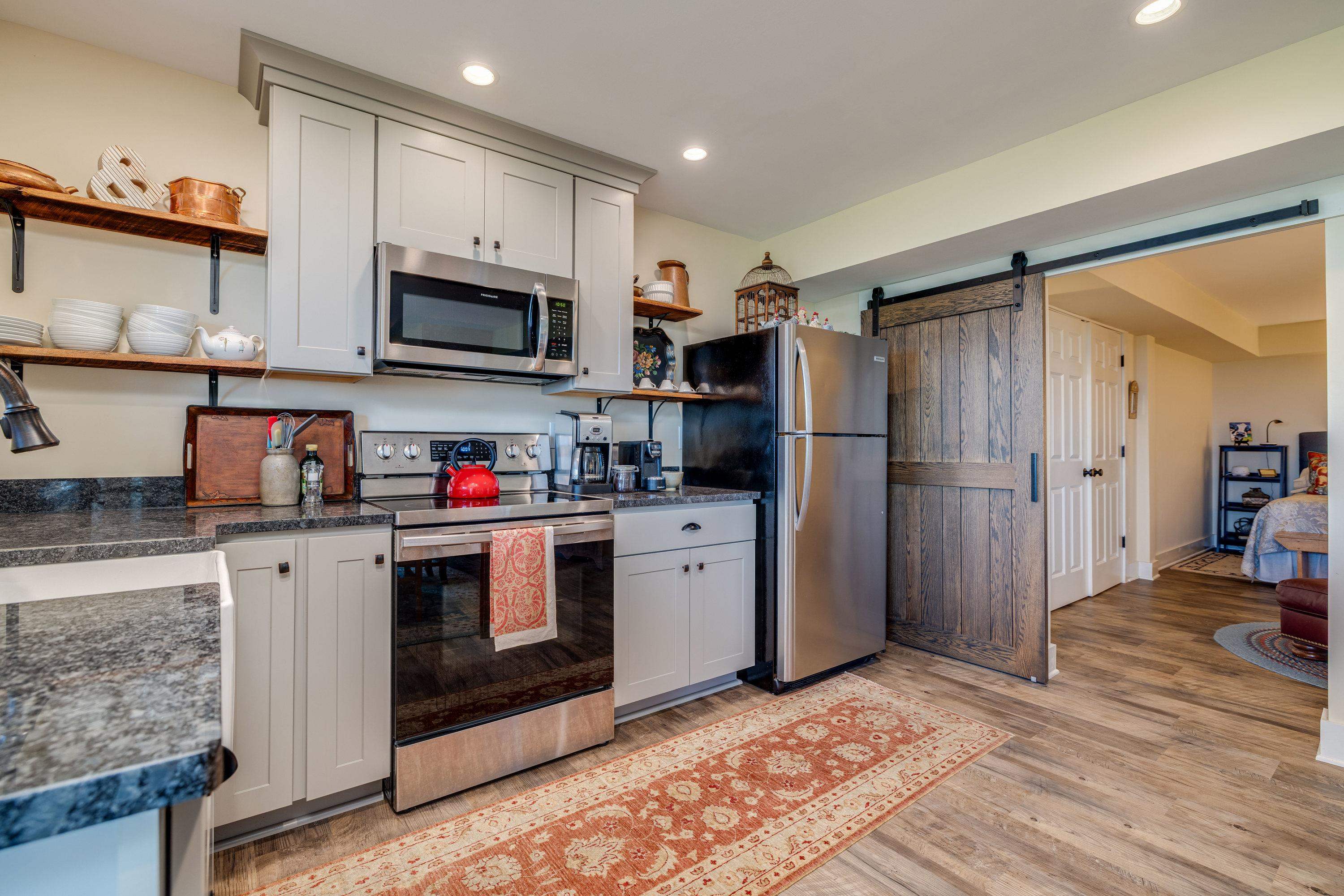 This second kitchen features wooden cabinetry throughout, luxury vinyl plank flooring, stainless steel appliances and much more!