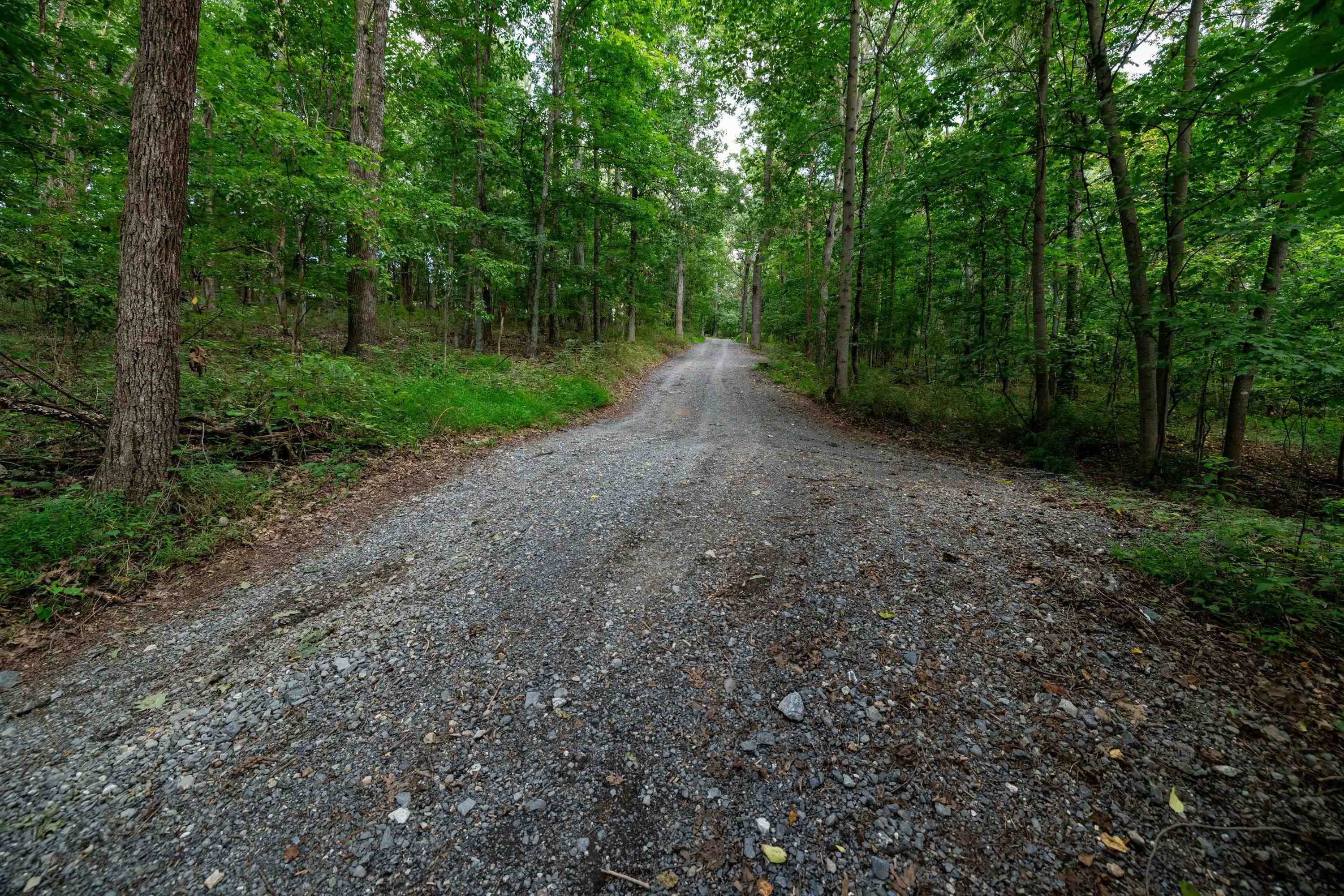 The gravel driveway offers wooded views for a portion of the drive.  This driveway offers lots of privacy.