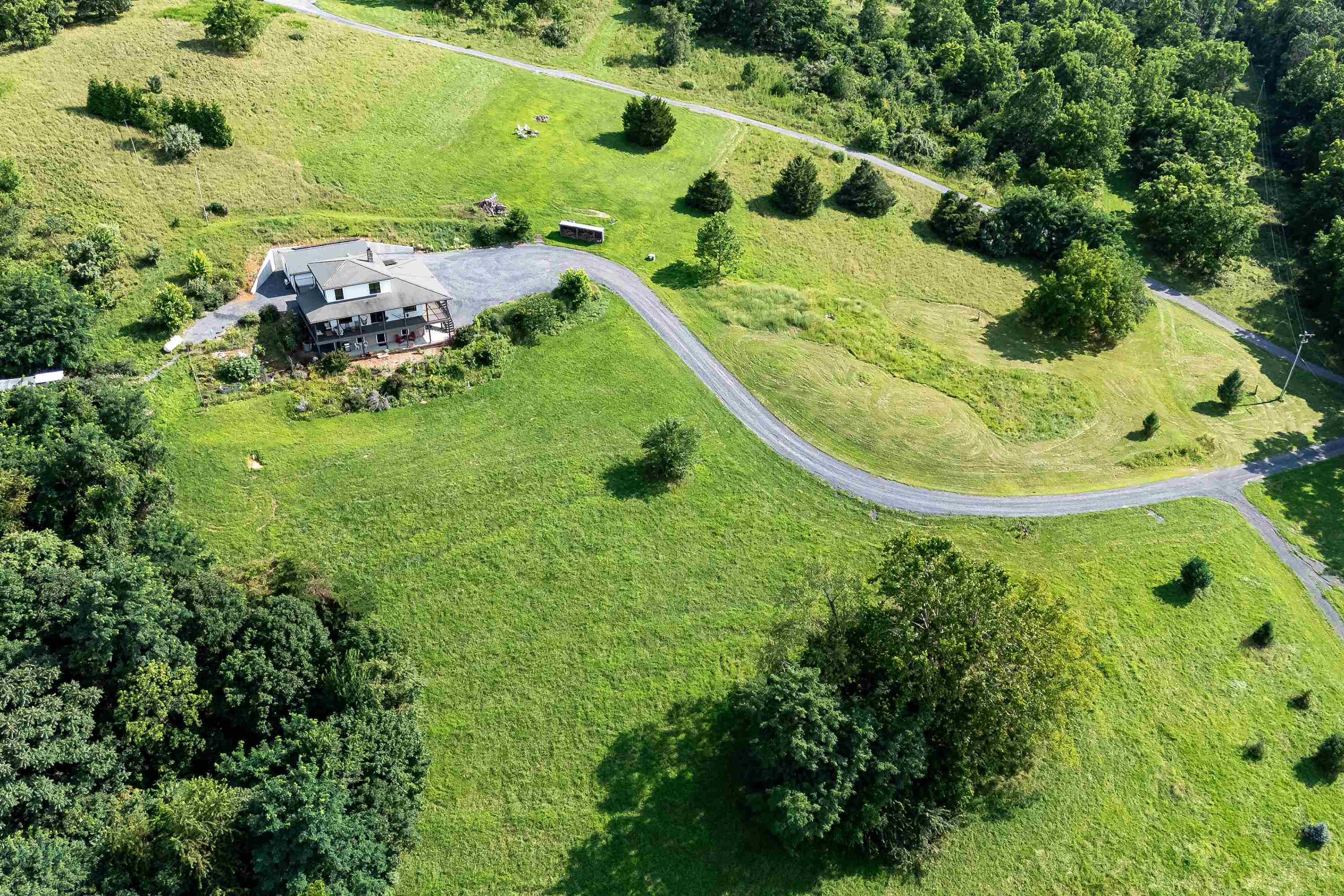 The aerial view shows off the beauty of the views surrounding the home.  From the porch you can view the mountains, valley, and overlook the spacious lot surrounding the home.