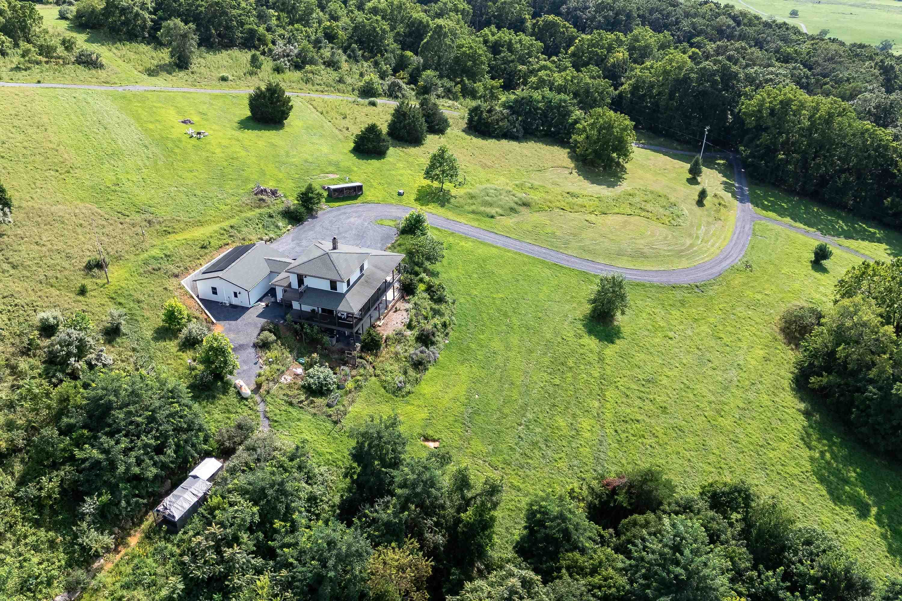 The aerial view shows off the beauty of the views surrounding the home.  From the porch you can view the mountains, valley, and overlook the spacious lot surrounding the home.
