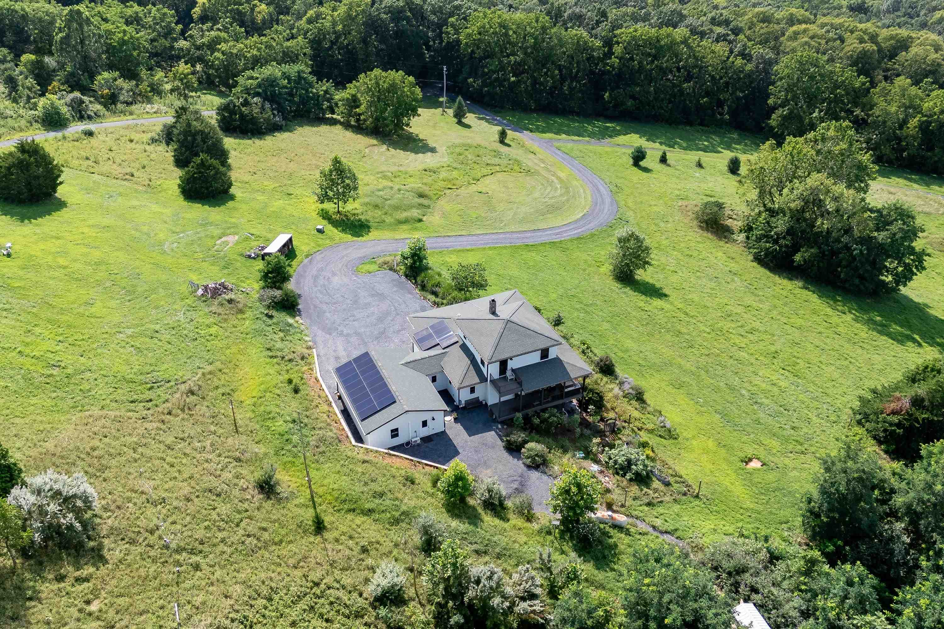 The aerial view shows off the beauty of the views surrounding the home.  From the porch you can view the mountains, valley, and overlook the spacious lot surrounding the home.