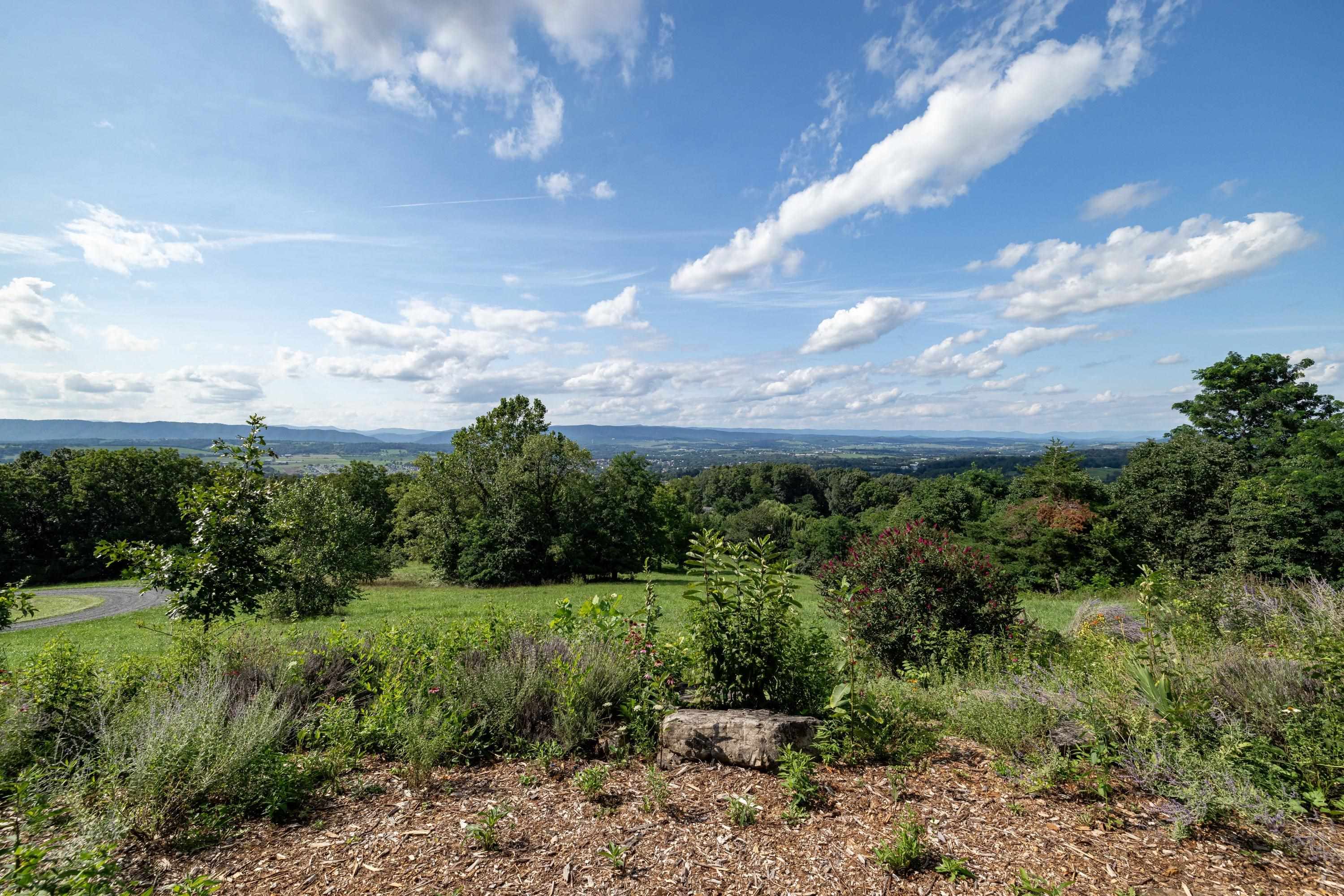 The aerial view shows off the beauty of the views surrounding the home.  From the porch you can view the mountains, valley, and overlook the spacious lot surrounding the home.