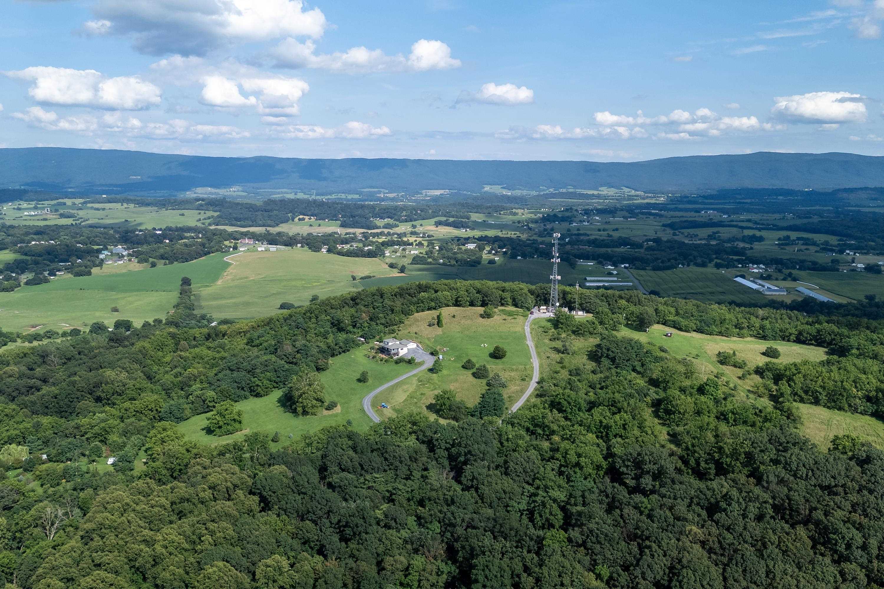 The aerial view shows off the beauty of the views surrounding the home.  From the porch you can view the mountains, valley, and overlook the spacious lot surrounding the home.