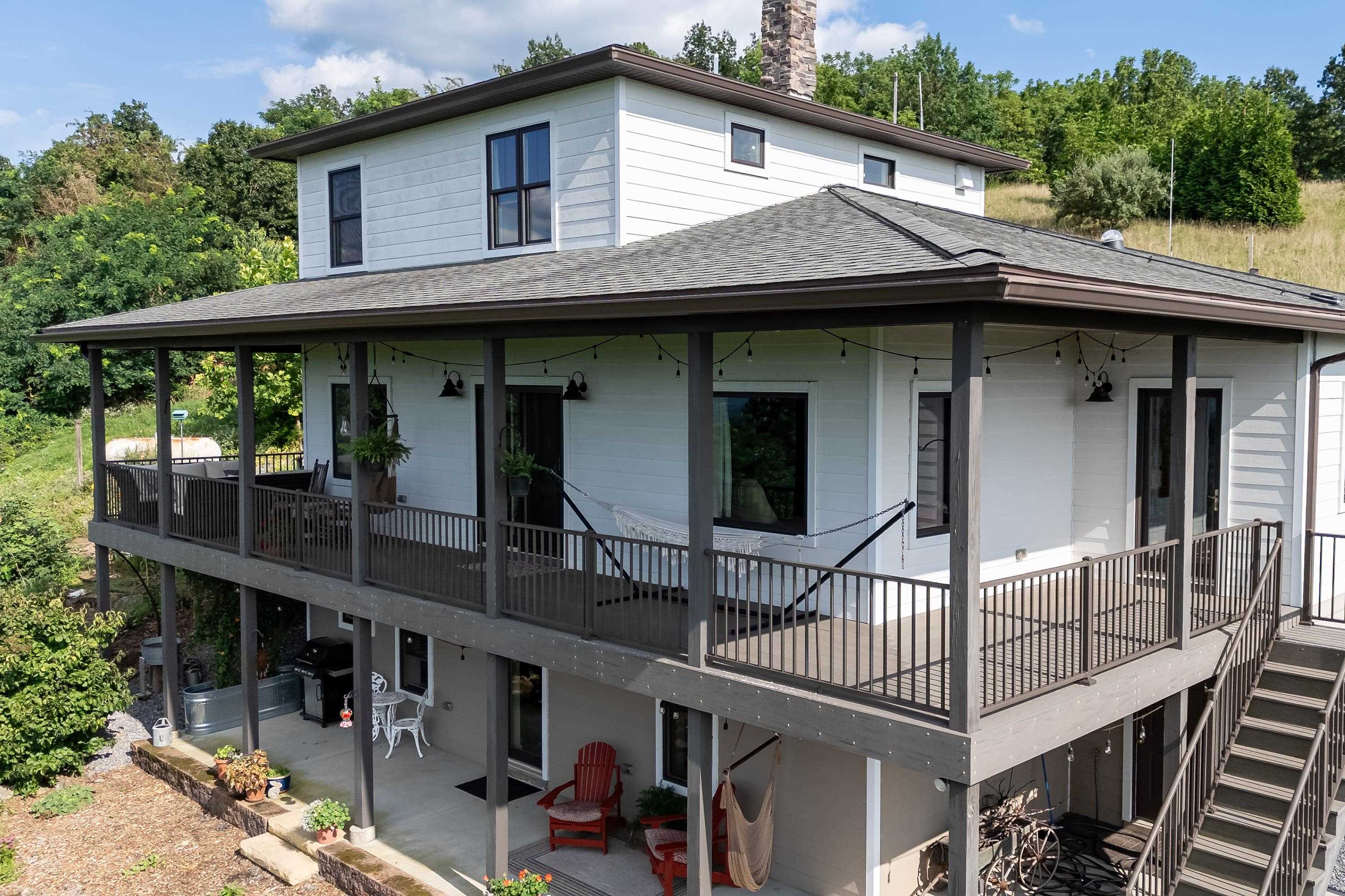 The front view of the beautiful home located at 11180 Daphna Road.  This front view highlights the large parking area, spacious covered from porch and patio, hardy plank siding, and very spacious lot with outstanding views!