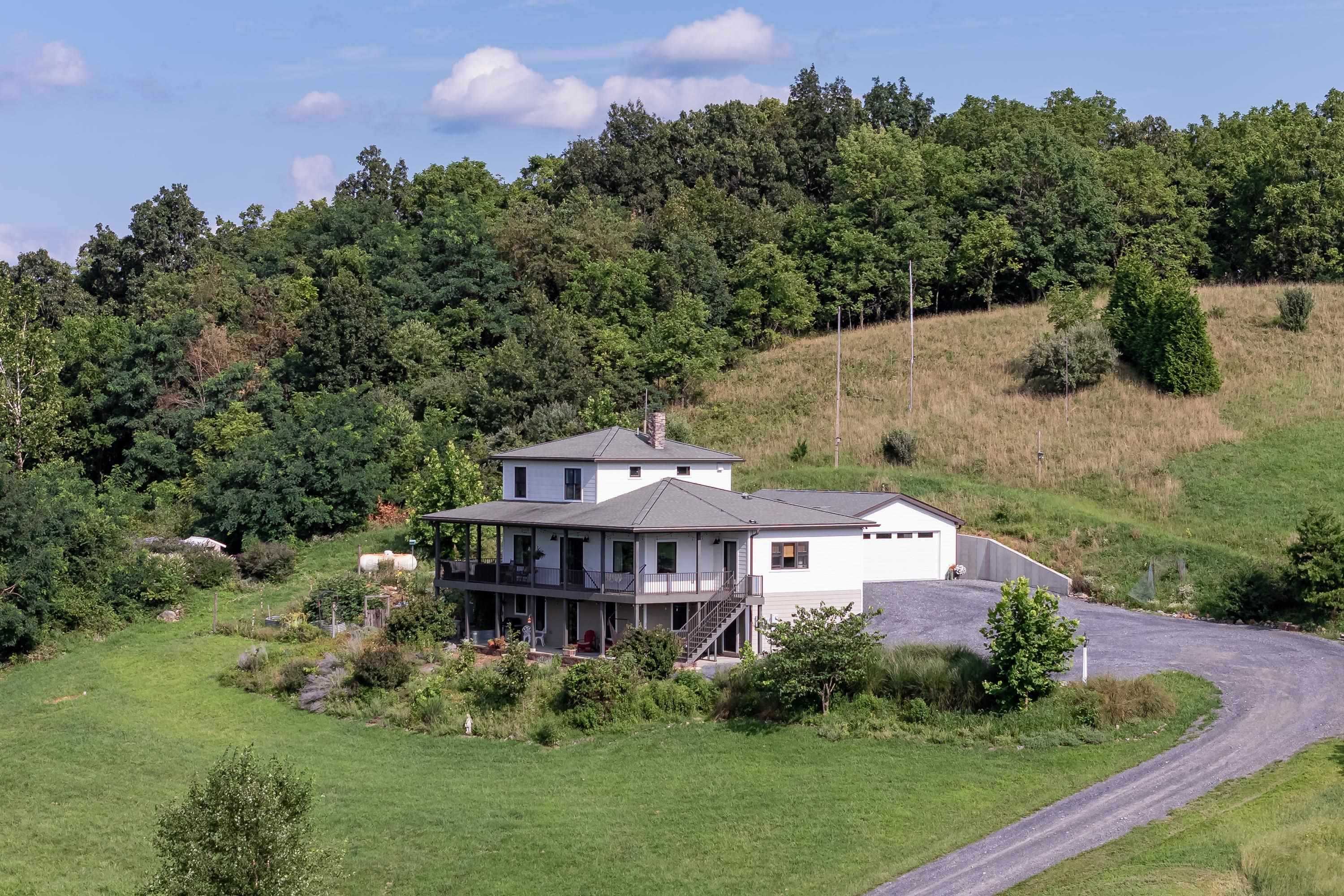 The aerial view shows off the beauty of the views surrounding the home.  From the porch you can view the mountains, valley, and overlook the spacious lot surrounding the home.