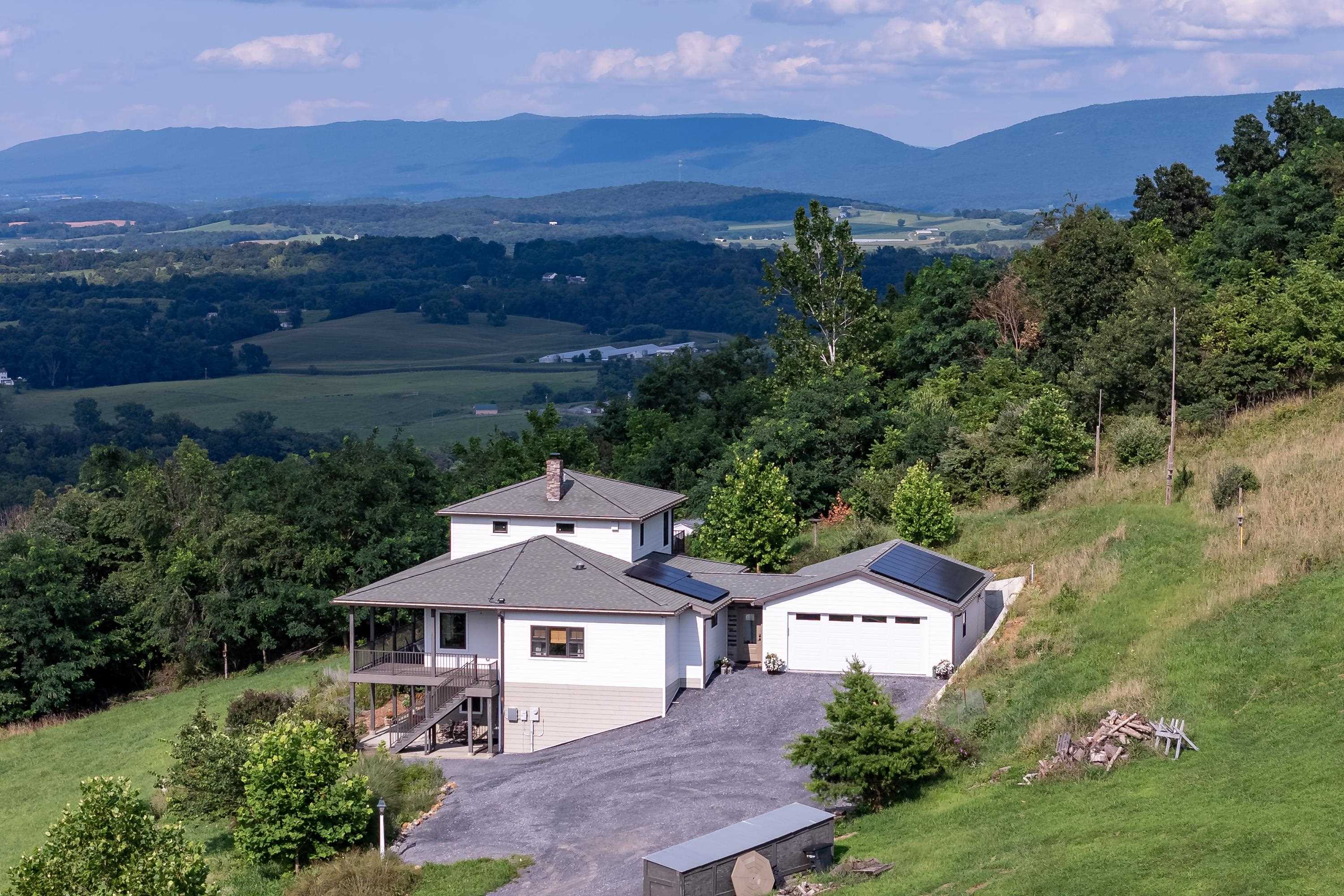 The aerial view shows off the beauty of the views surrounding the home.  From the porch you can view the mountains, valley, and overlook the spacious lot surrounding the home.