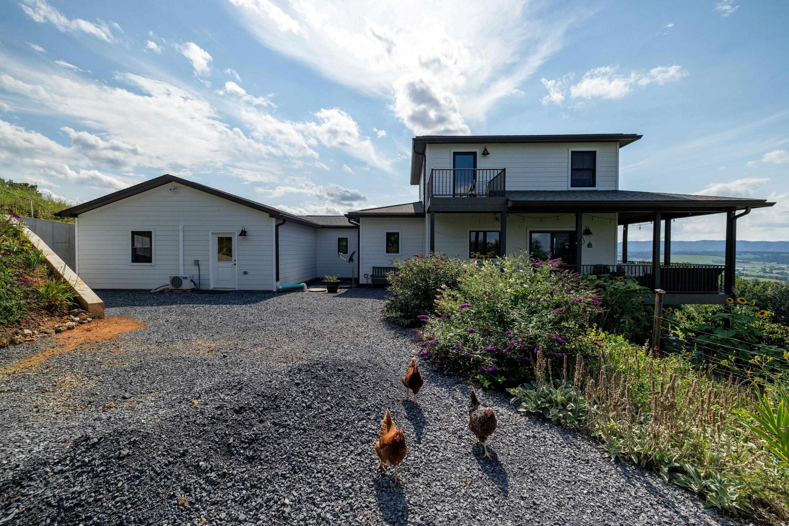 The front view of the beautiful home located at 11180 Daphna Road.  This front view highlights the large parking area, spacious covered from porch and patio, hardy plank siding, and very spacious lot with outstanding views!