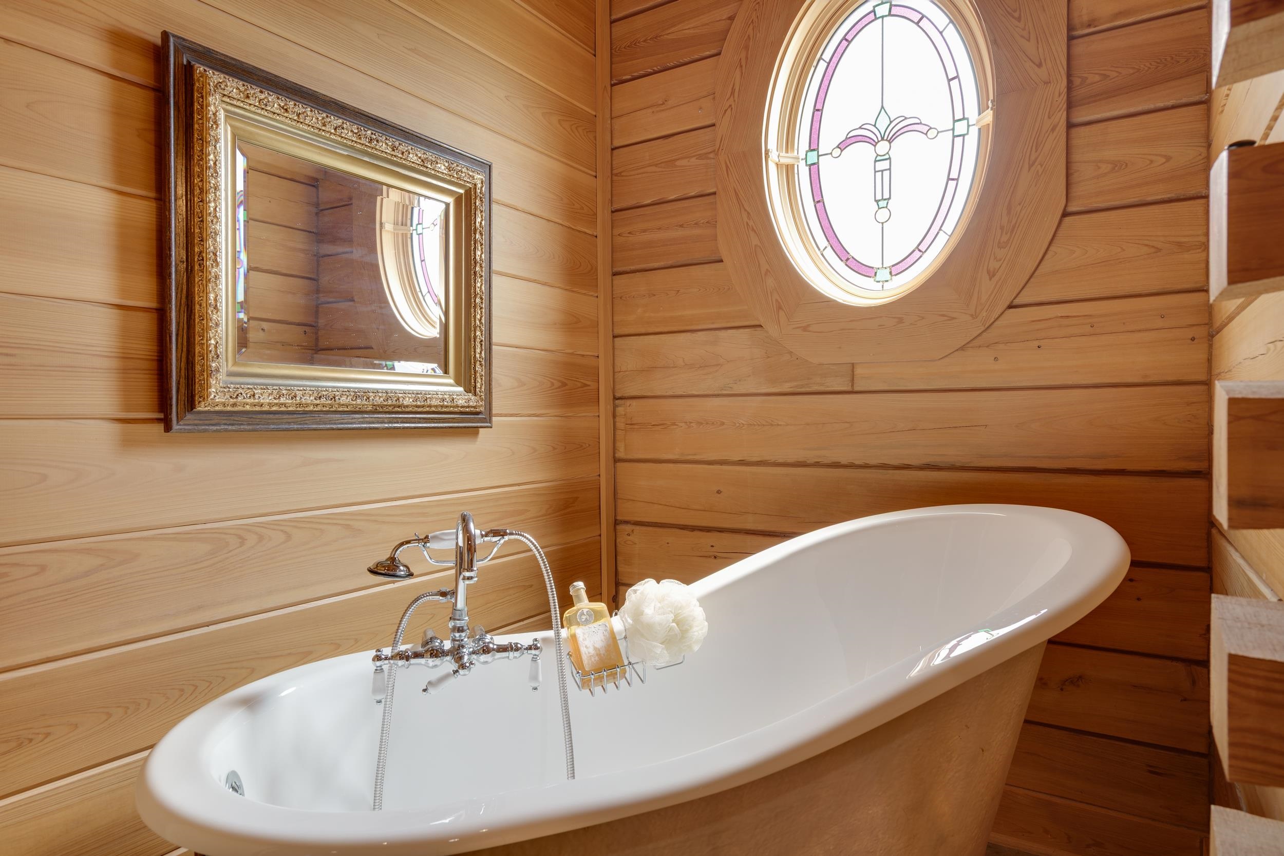 Claw Tub soaking tub shined on by the sun through the stainglass window