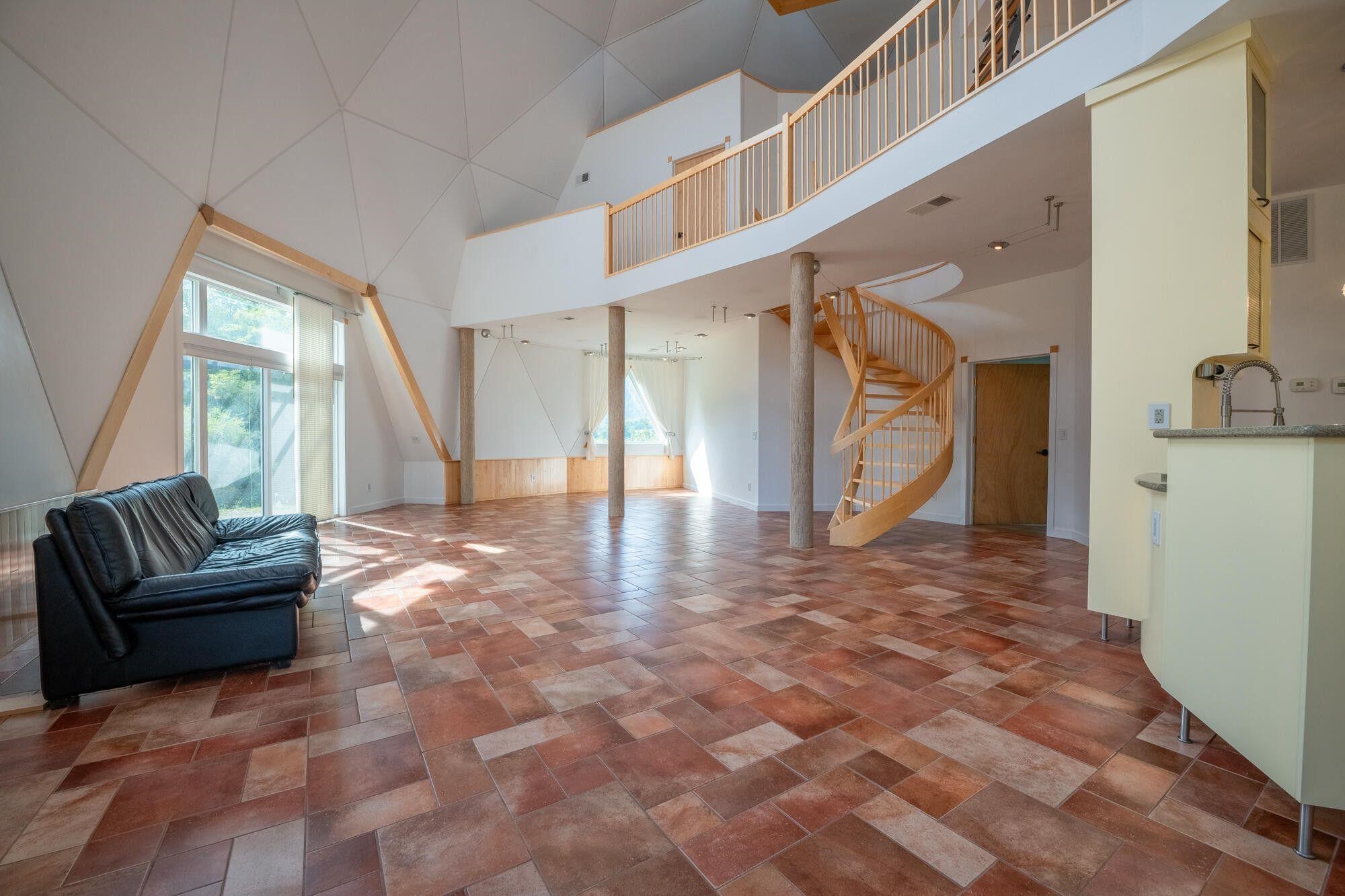 Open floor plan allows kitchen, dining area, living room gathering space, spiral stair to the 2nd Floor and balcony.