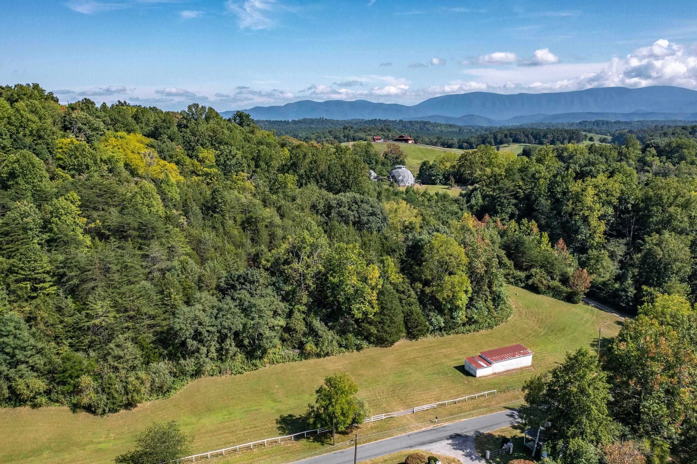 Distant view of the property shows the pasture, and the homes on the hill above.