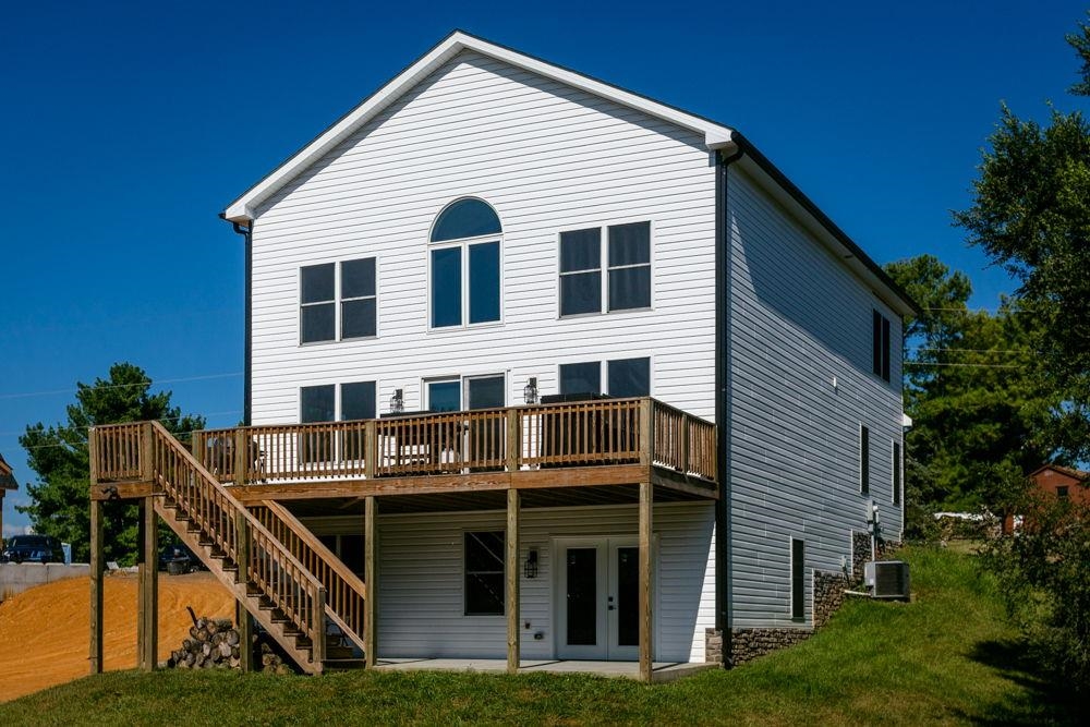 Looking from the north with upper open deck and lower covered patio with basement entrance.